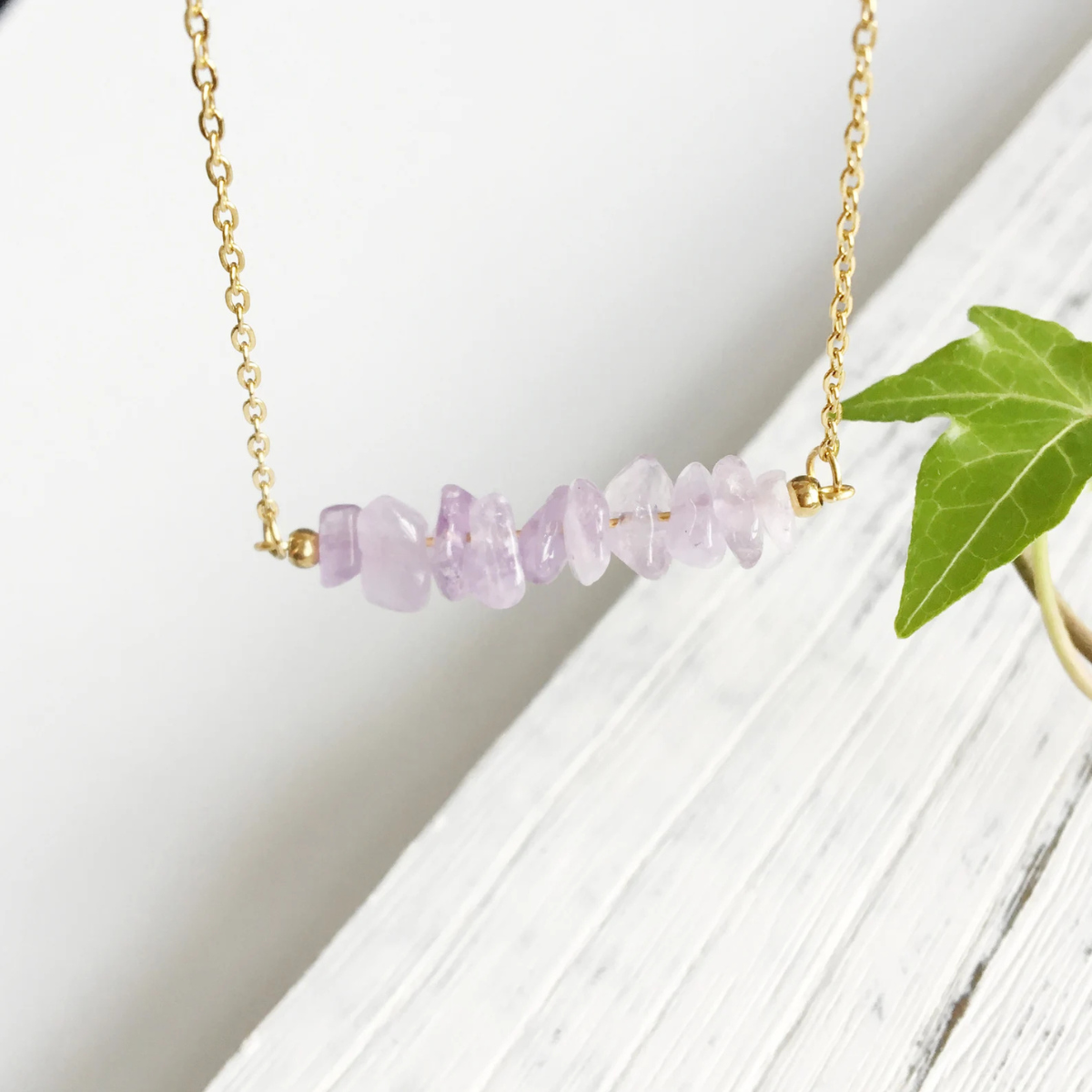 Zoomed-in look at purple amethyst stone chips on necklace, highlighting handmade artistry