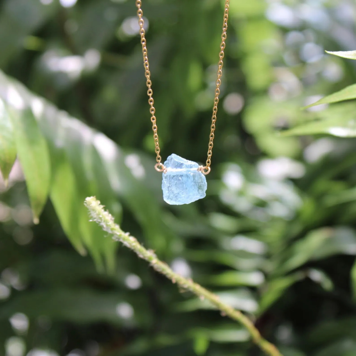 Close-up of aquamarine raw stone necklace showcasing natural crystal texture