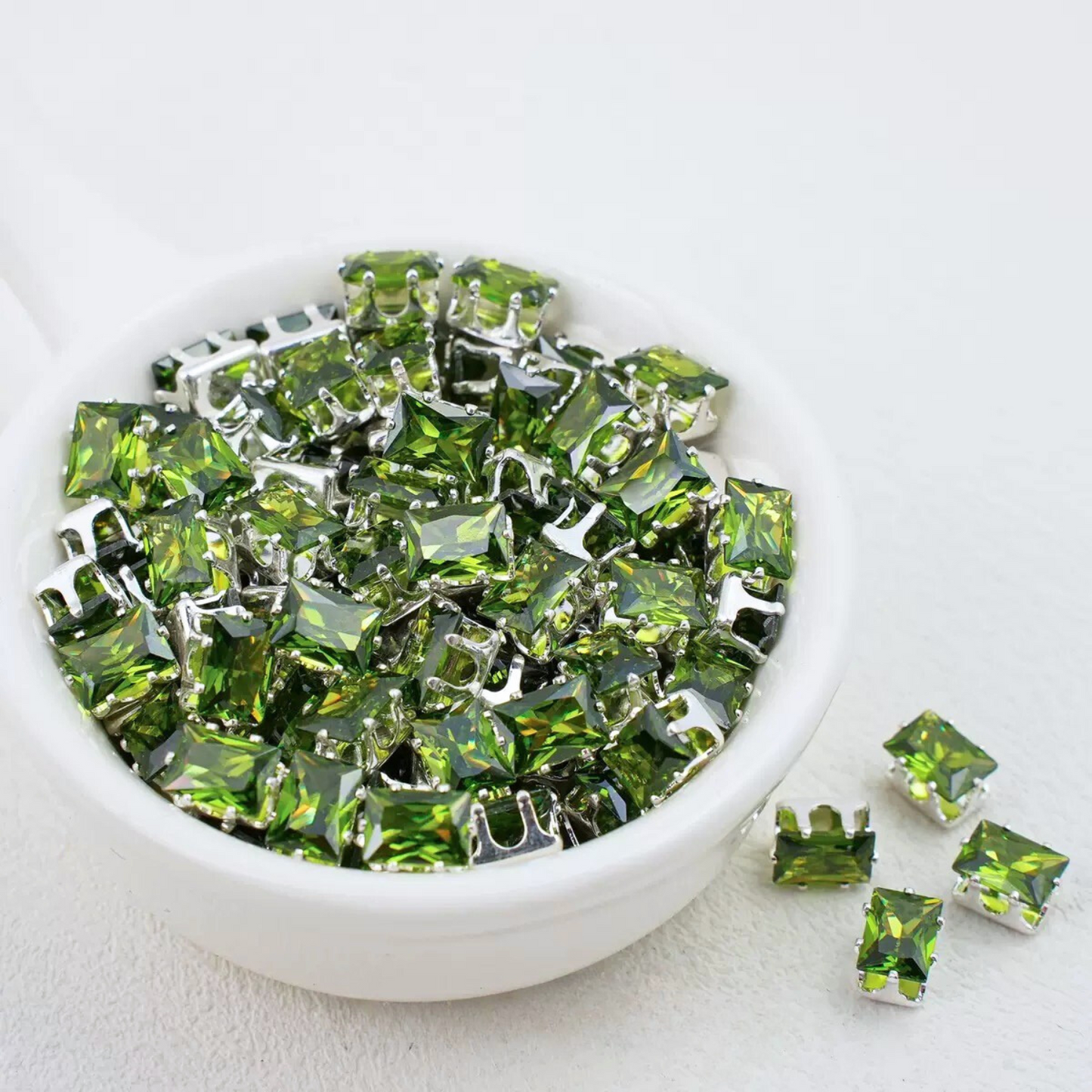 Olive green rectangular zirconia in silver-tone claw settings