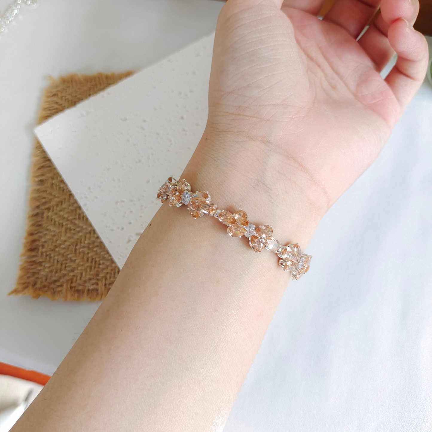 Elegant wrist wearing handmade bracelet with amber and white zircon
