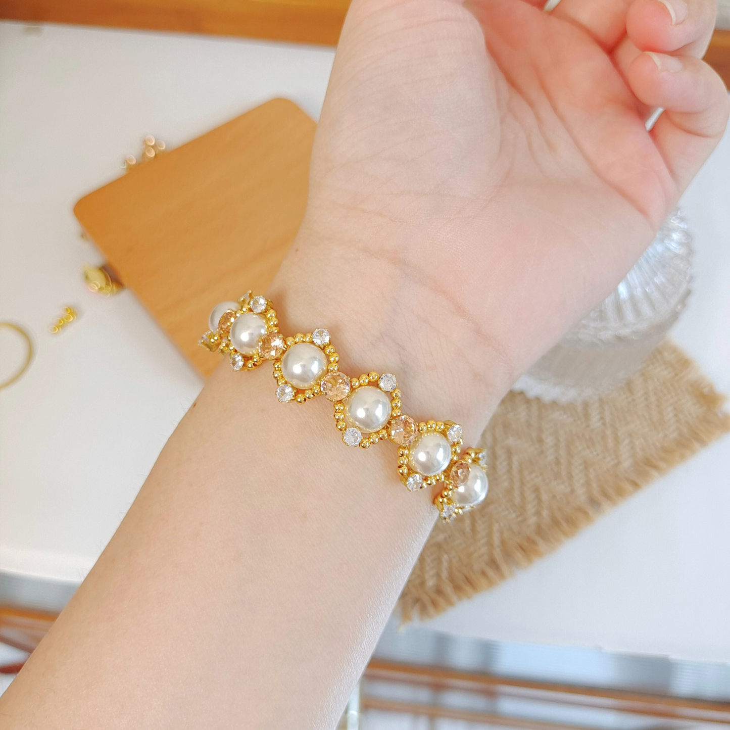 Model showing cute LinaBell charm with elegant pearl bracelet