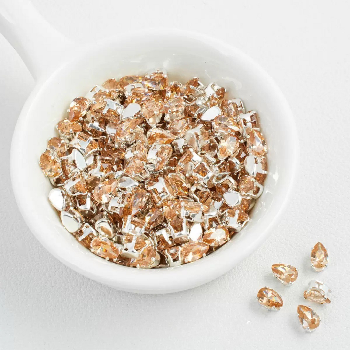 Champagne eardrop-shaped zircon spacer bead in silver finish