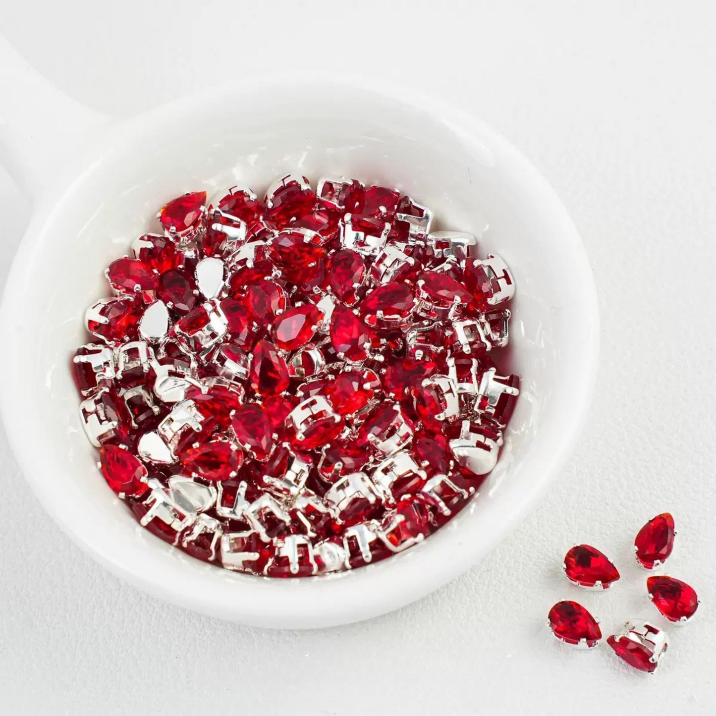 Red teardrop-shaped zircon spacer bead in silver finish