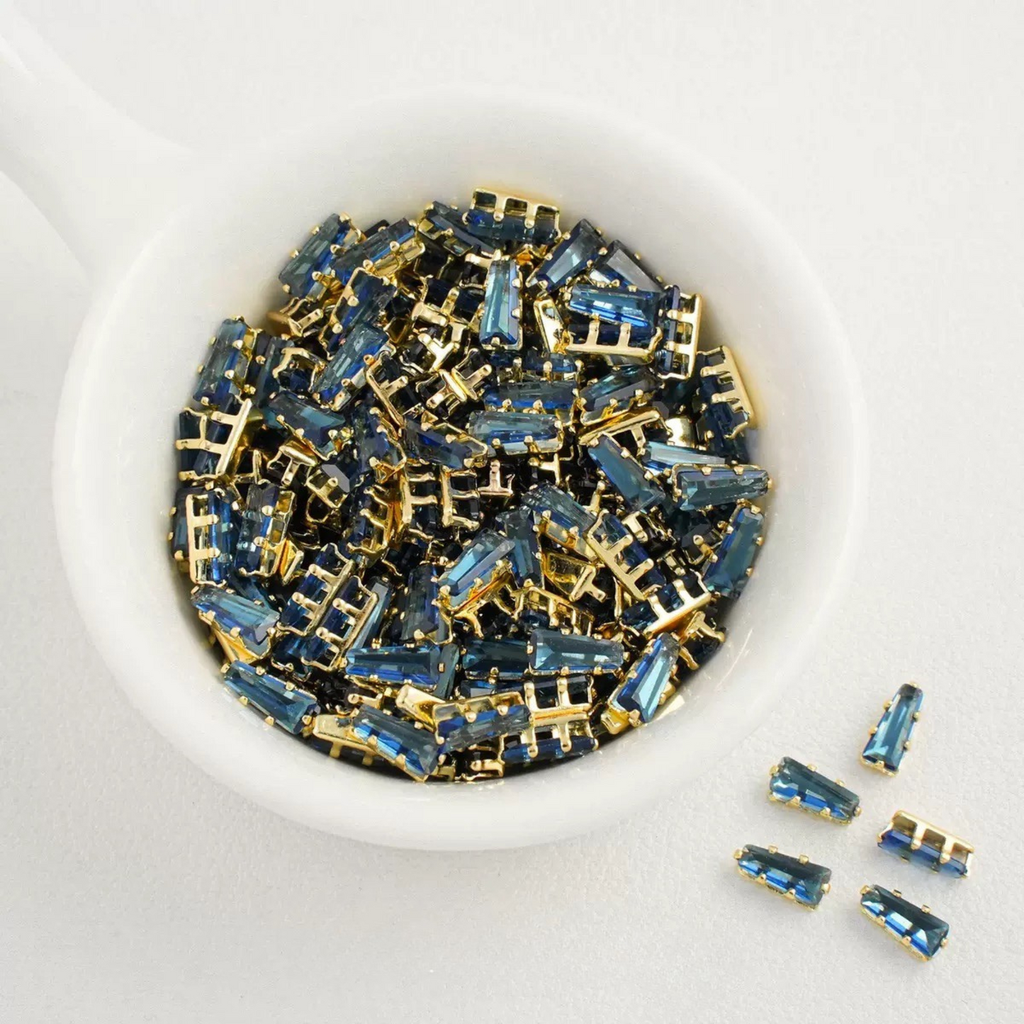 Dark blue trapezoid-shaped zircon spacer with gold backing