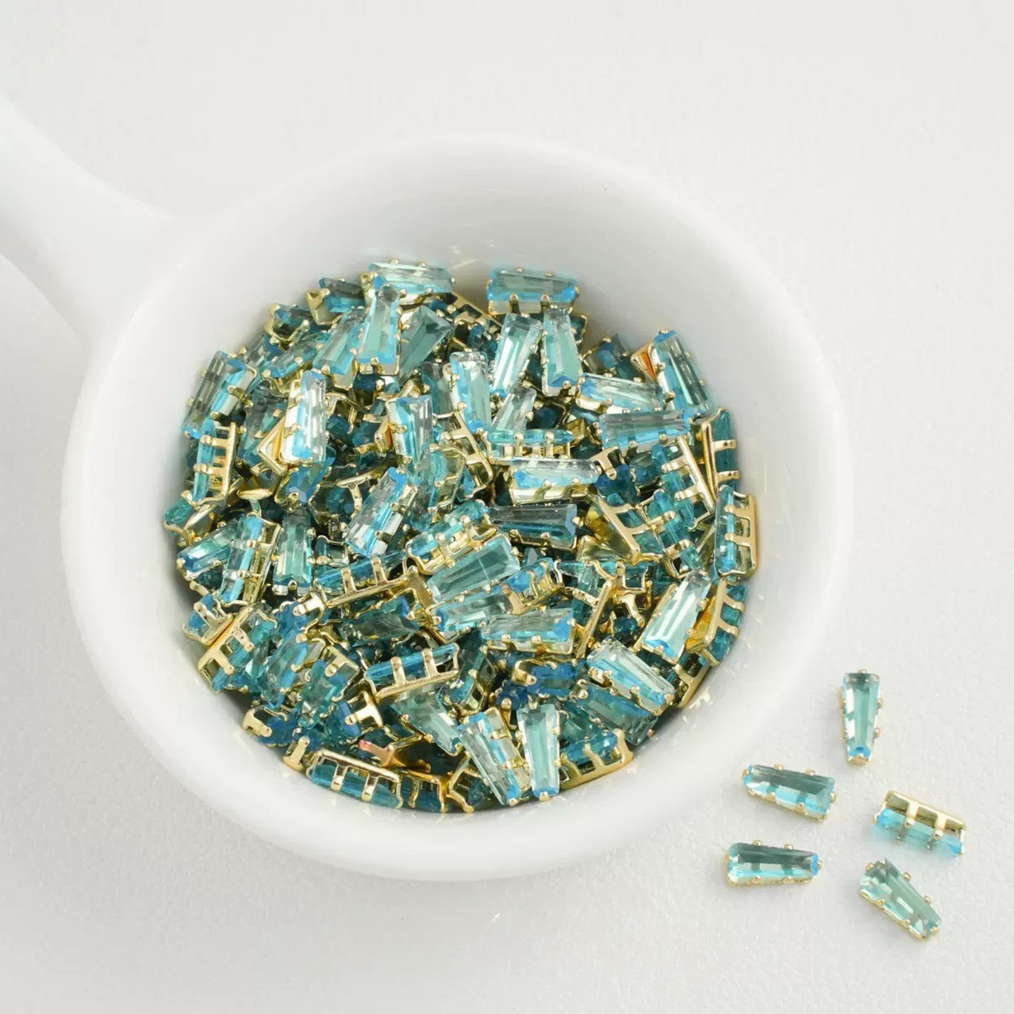 Lake blue trapezoid-shaped zircon spacer with gold backing