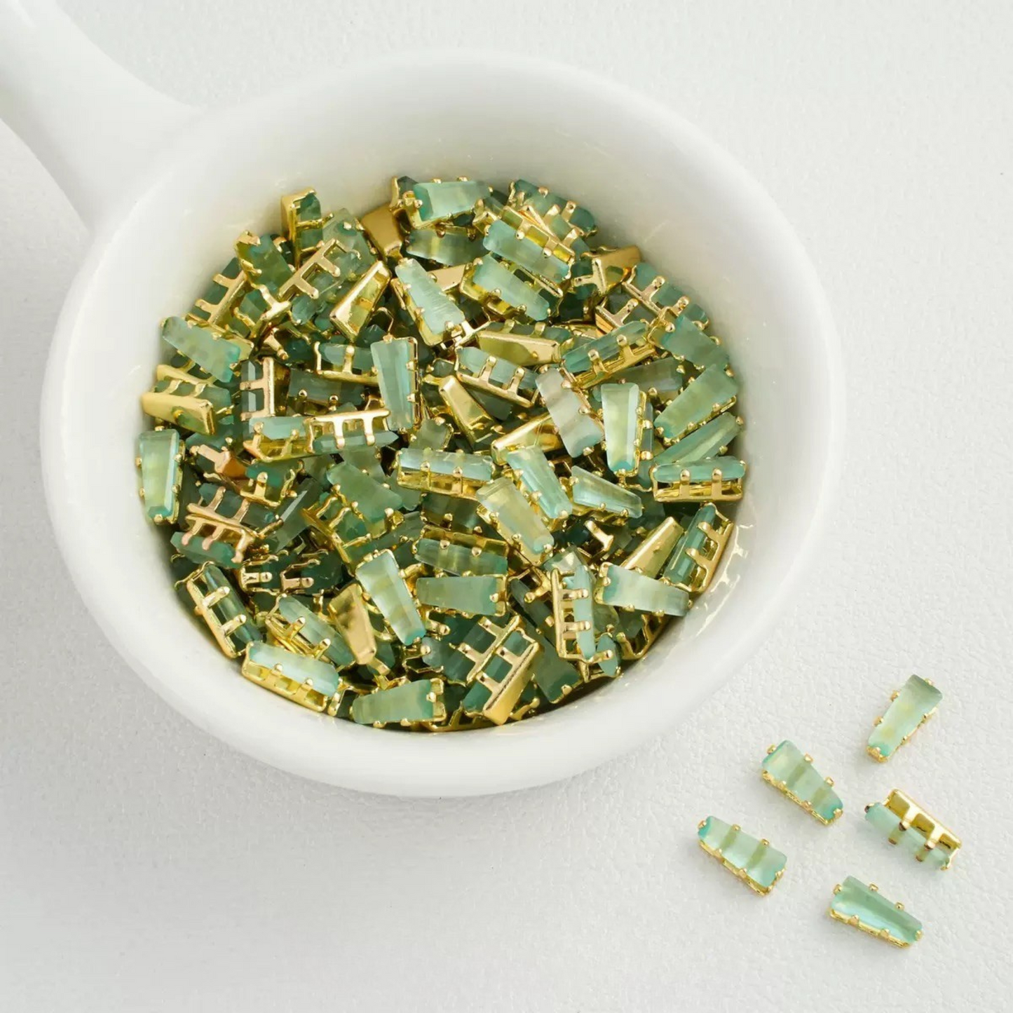Ligh green trapezoid-shaped zircon spacer with gold backing
