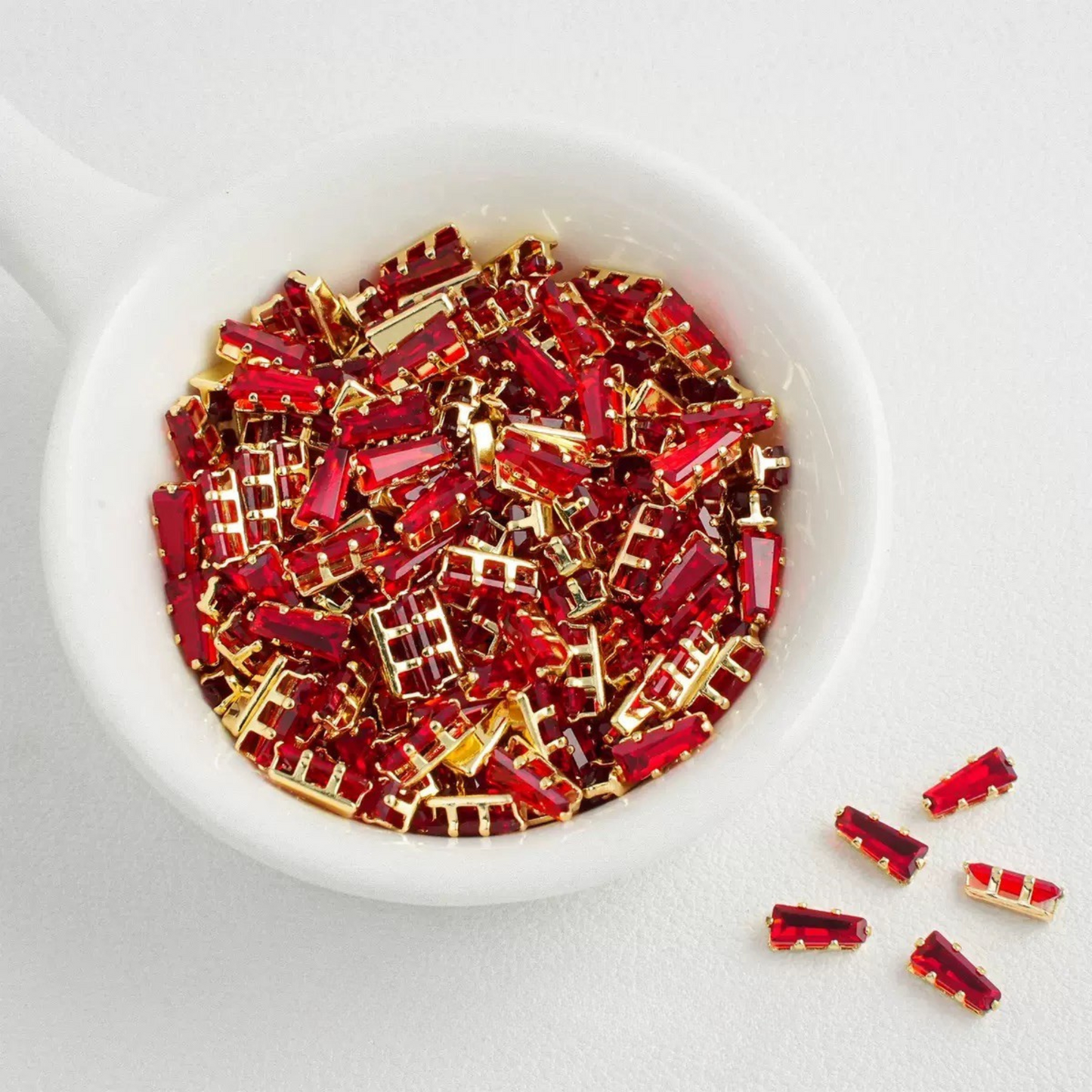 Red trapezoid-shaped zircon spacer with gold backing