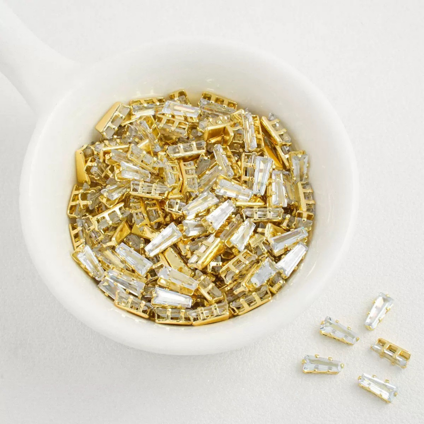 White trapezoid-shaped zircon spacer with gold backing
