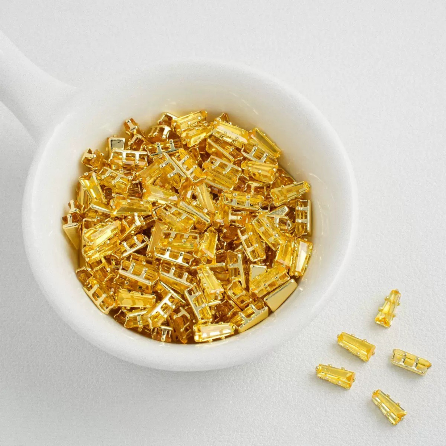 Yellow trapezoid-shaped zircon spacer with gold backing
