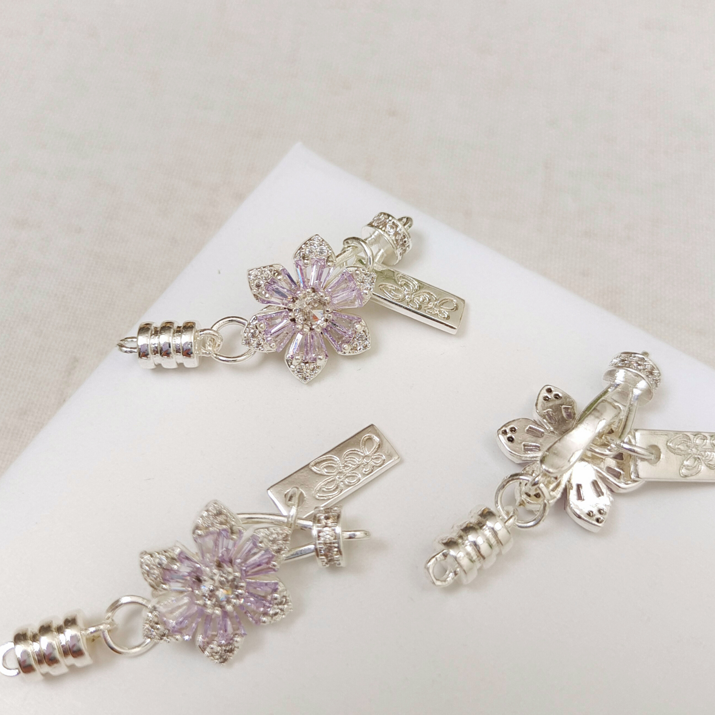 Front and back view of purple zircon cherry blossom clasp