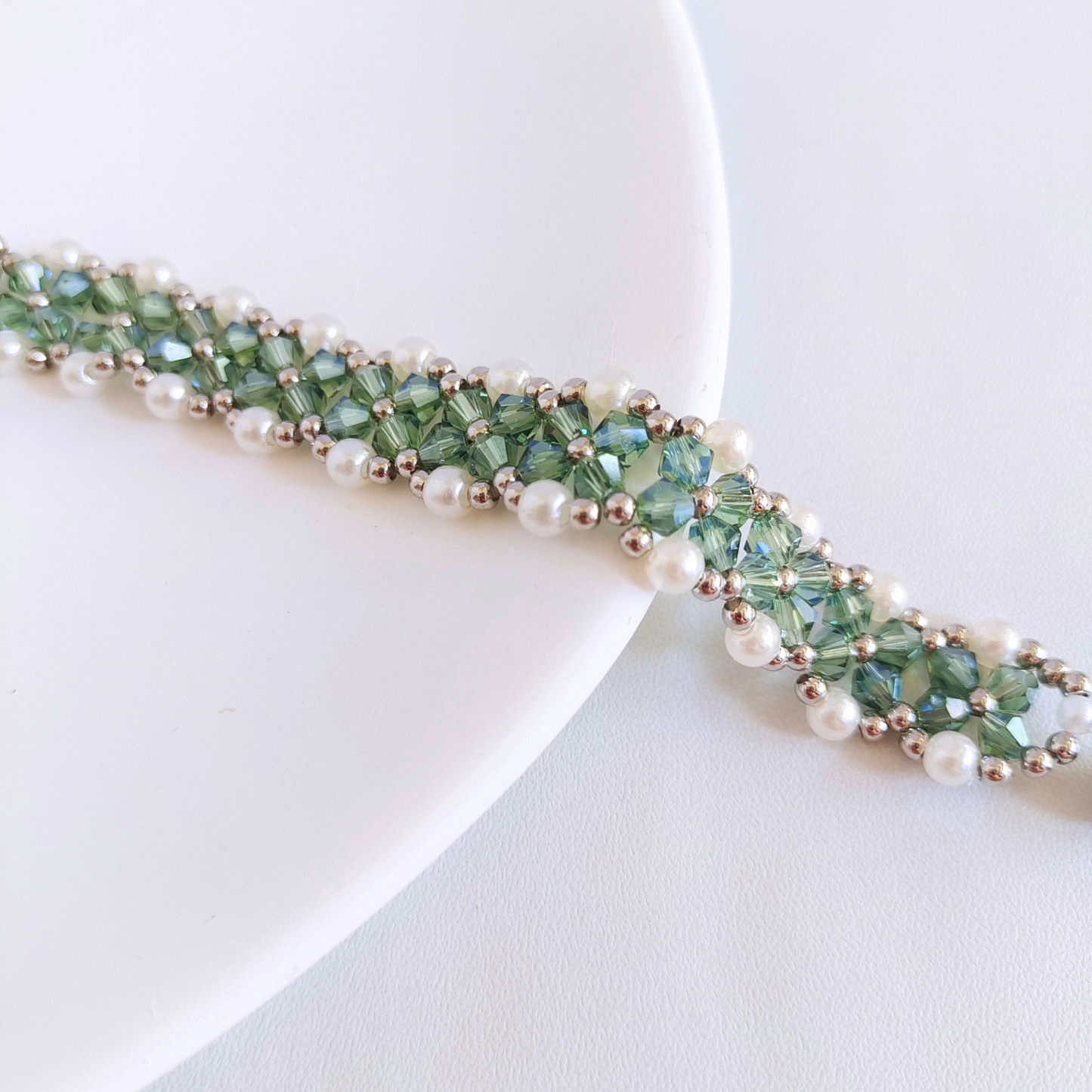 Finished beaded bracelet displayed alongside beading materials