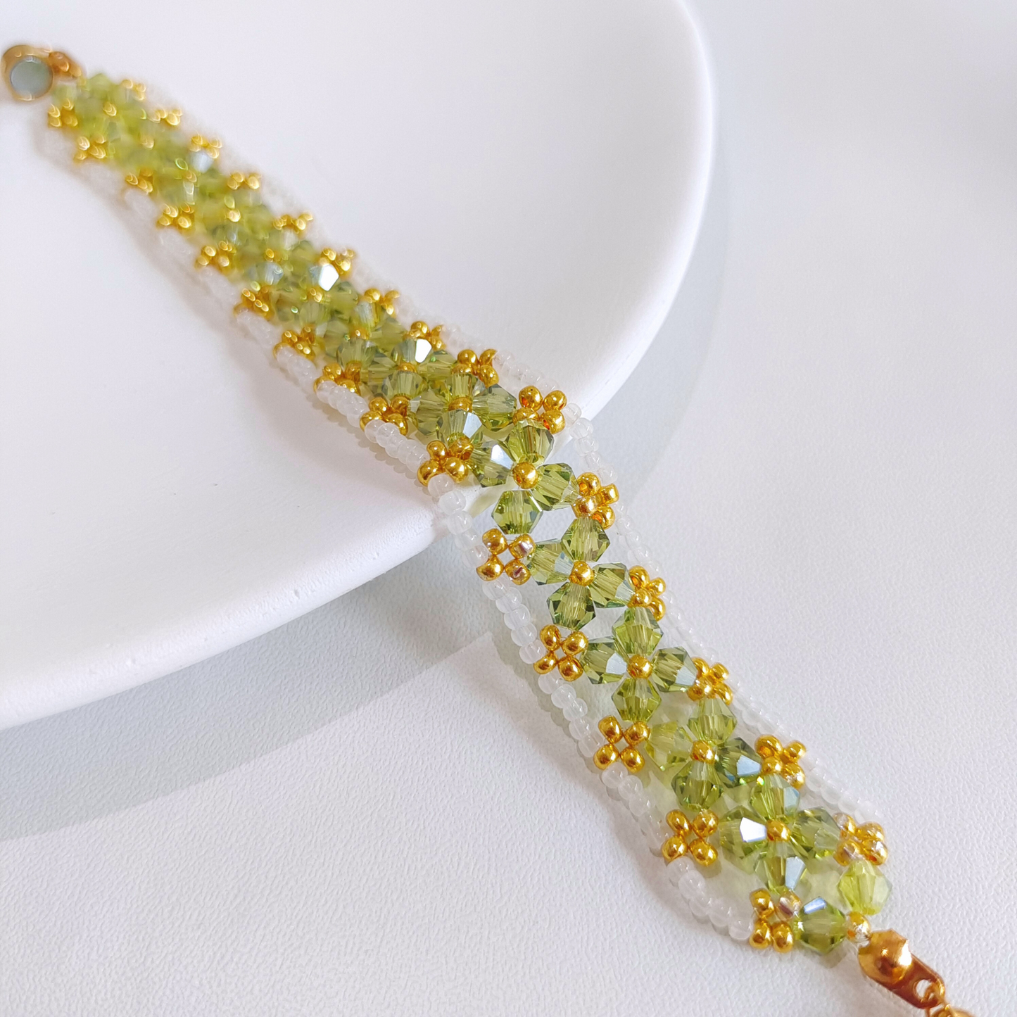 Detailed close-up of olive green beaded bracelet