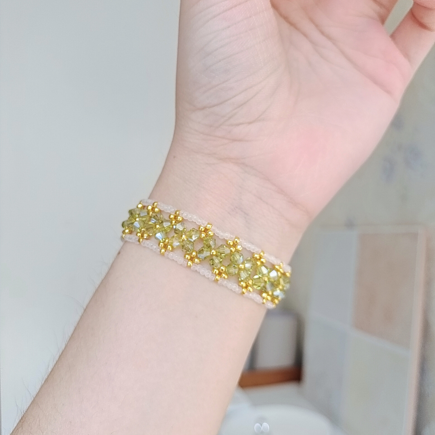 Handmade olive green and white bracelet on wrist