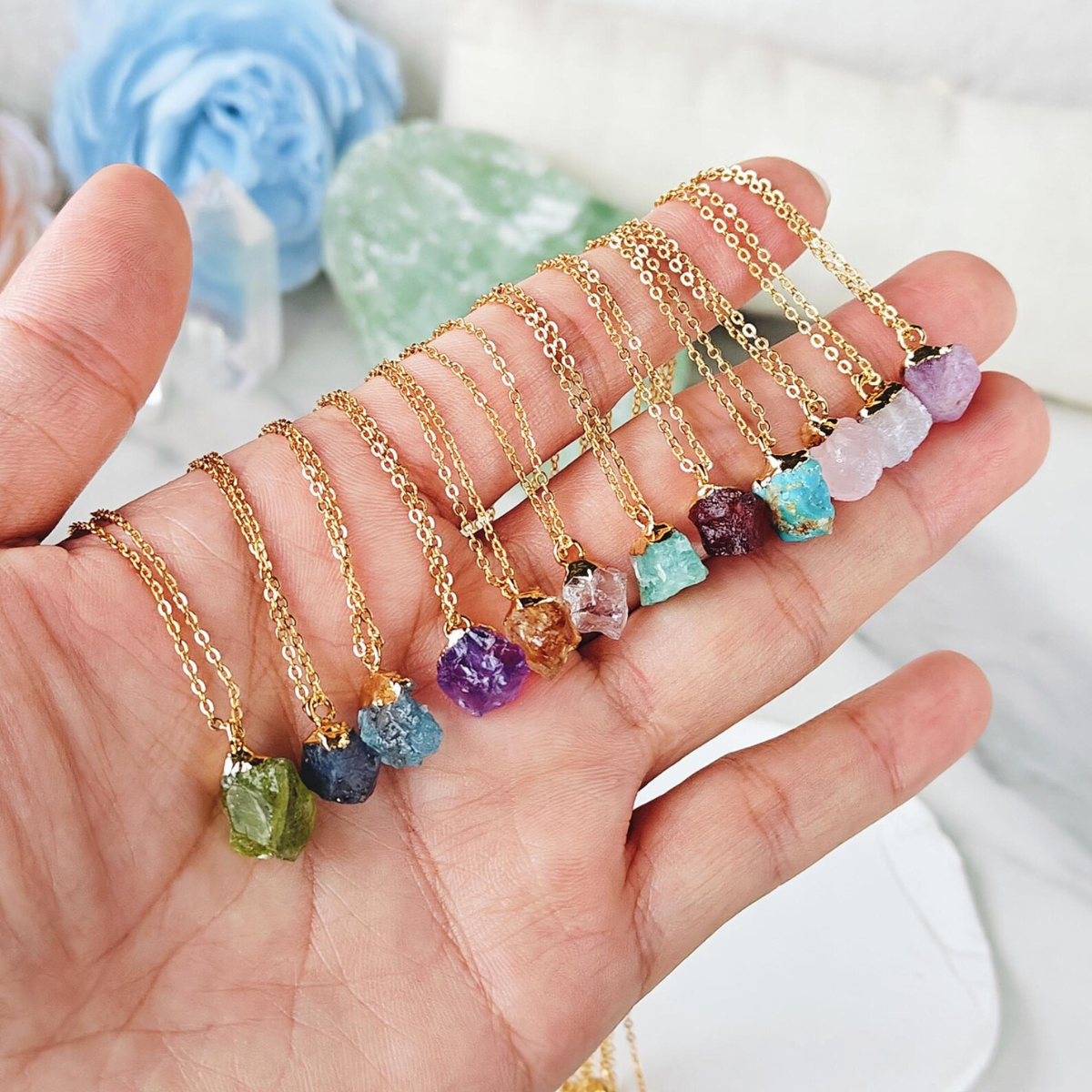 Full spectrum crystal raw stone necklace held in hand