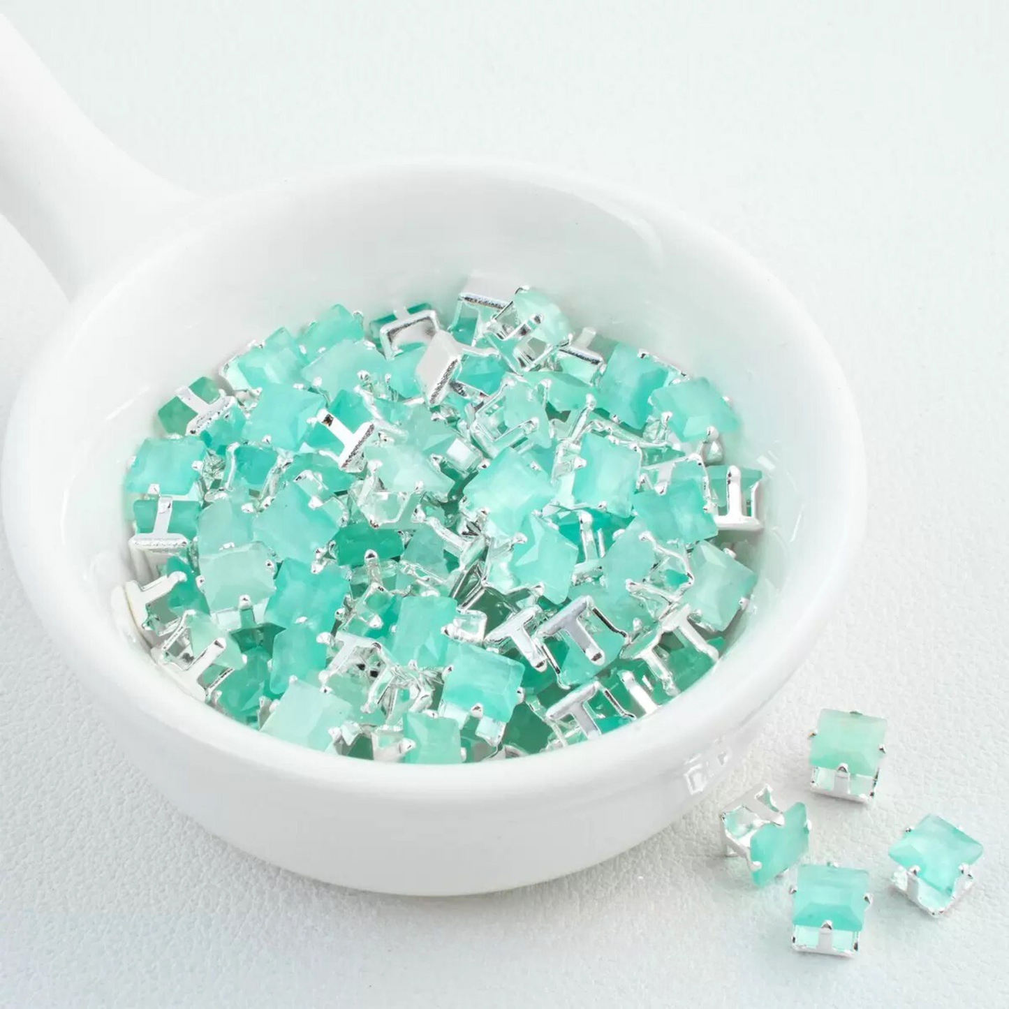 Precision-cut cat eye lake green square CZ in silver-plated prong settings