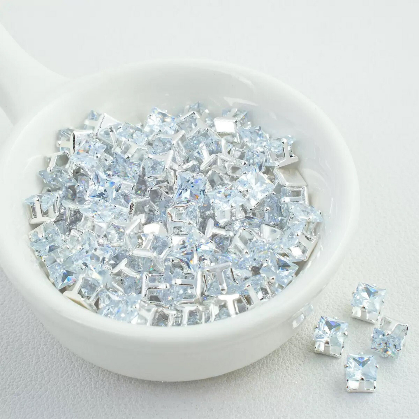 Precision-cut clear square CZ in silver-plated prong settings
