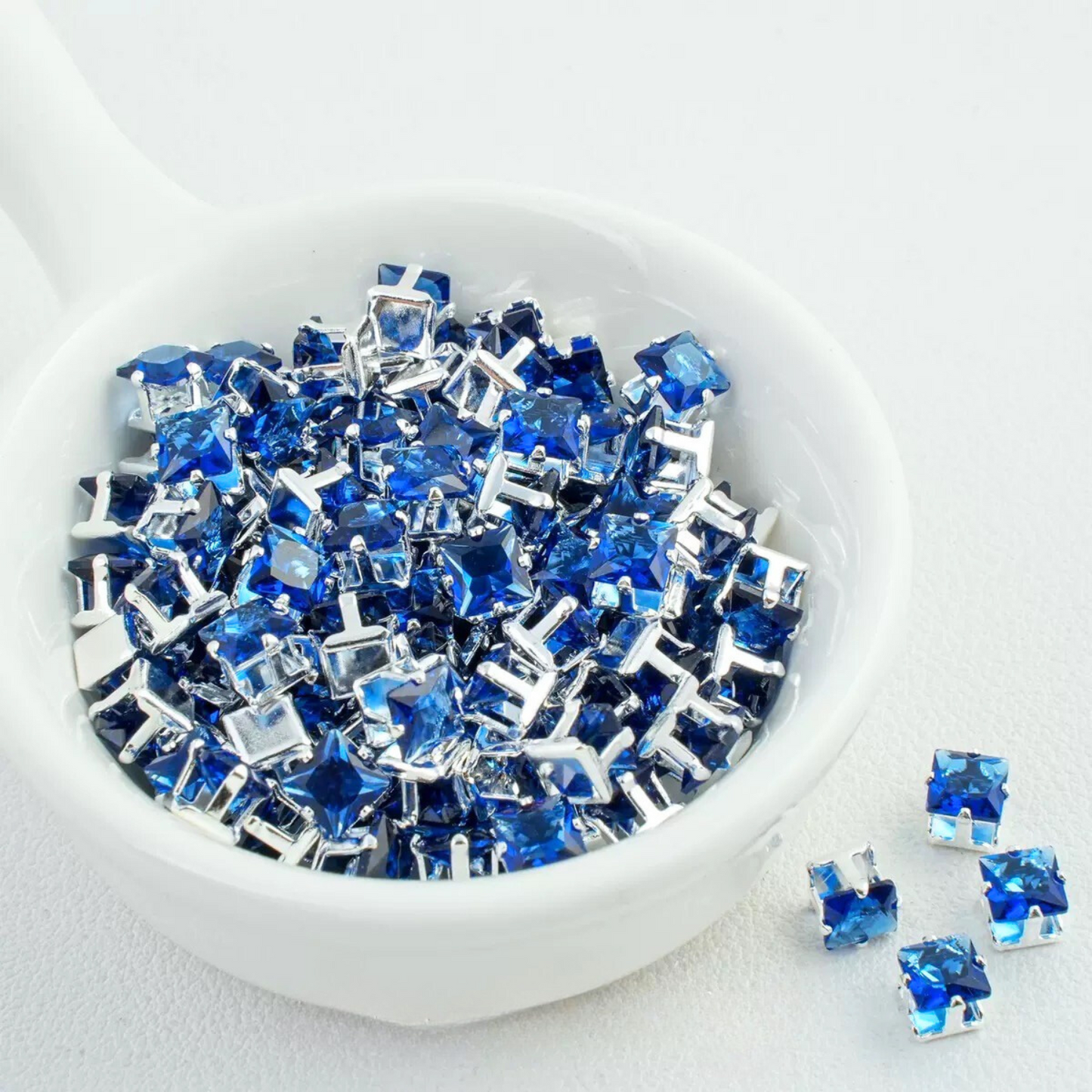 Precision-cut dark blue square CZ in silver-plated prong settings