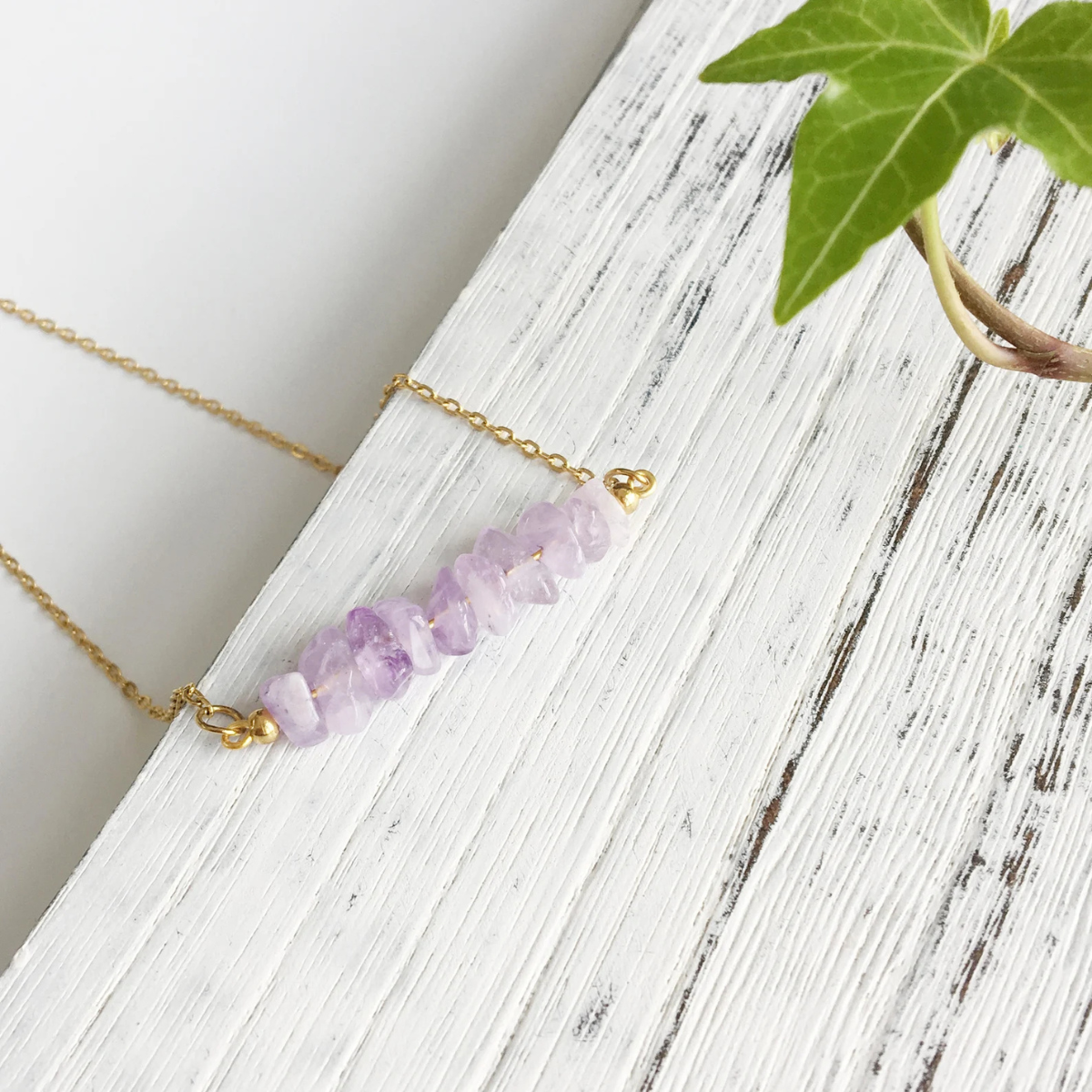 Partial view of amethyst chip necklace featuring raw crystal edges and delicate wirework