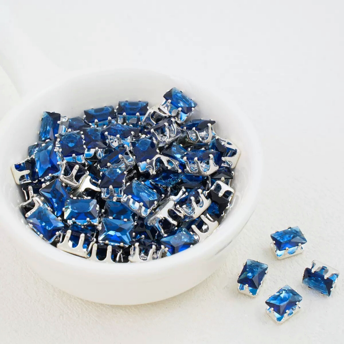 Dark blue rectangular zirconia in silver-tone claw settings