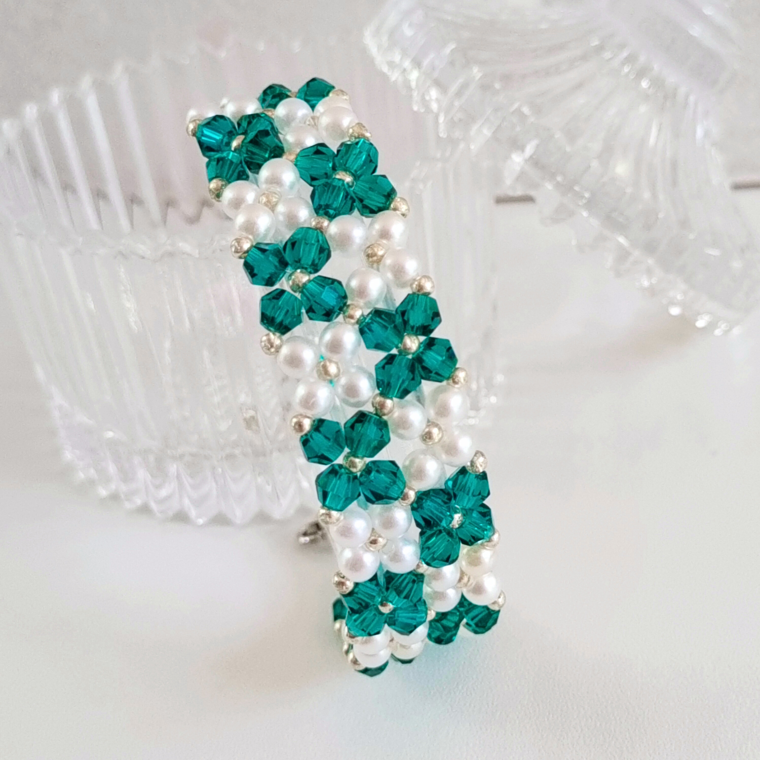 Macro shot of peacock green handmade bracelet showing bead pattern and texture