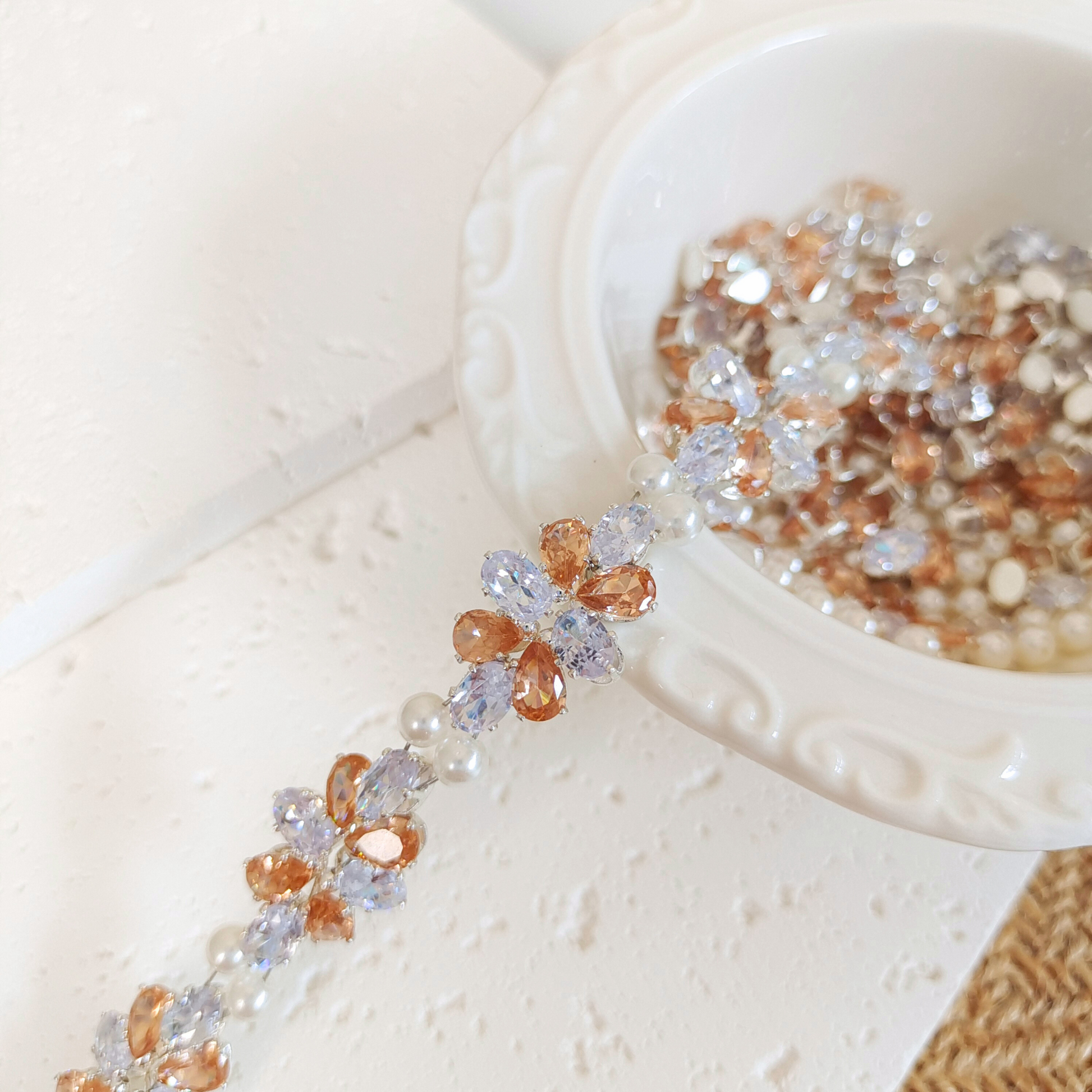 Detail of white oval zircon and amber teardrop zircon pearl bracelet