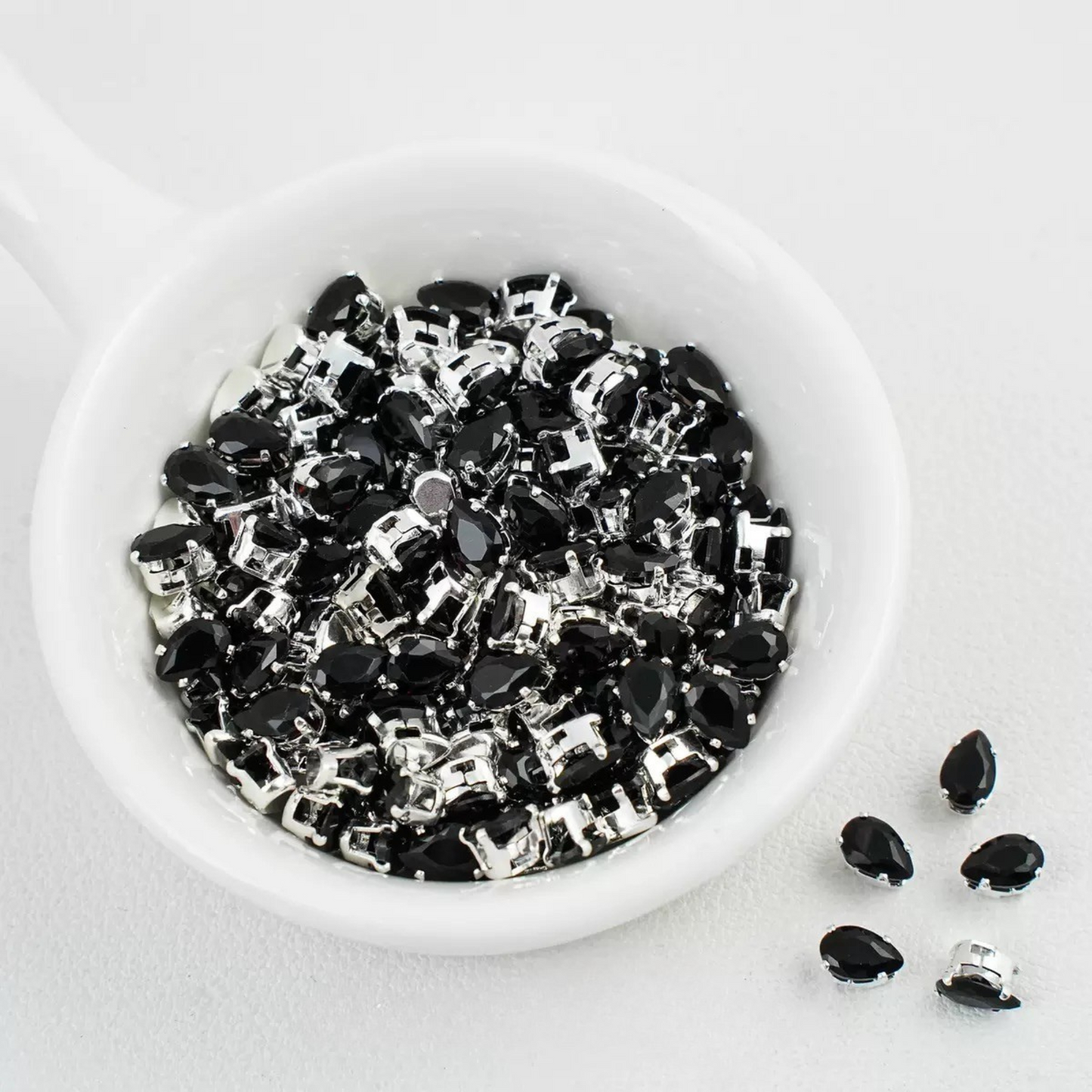 Black teardrop-shaped zircon spacer bead in silver finish
