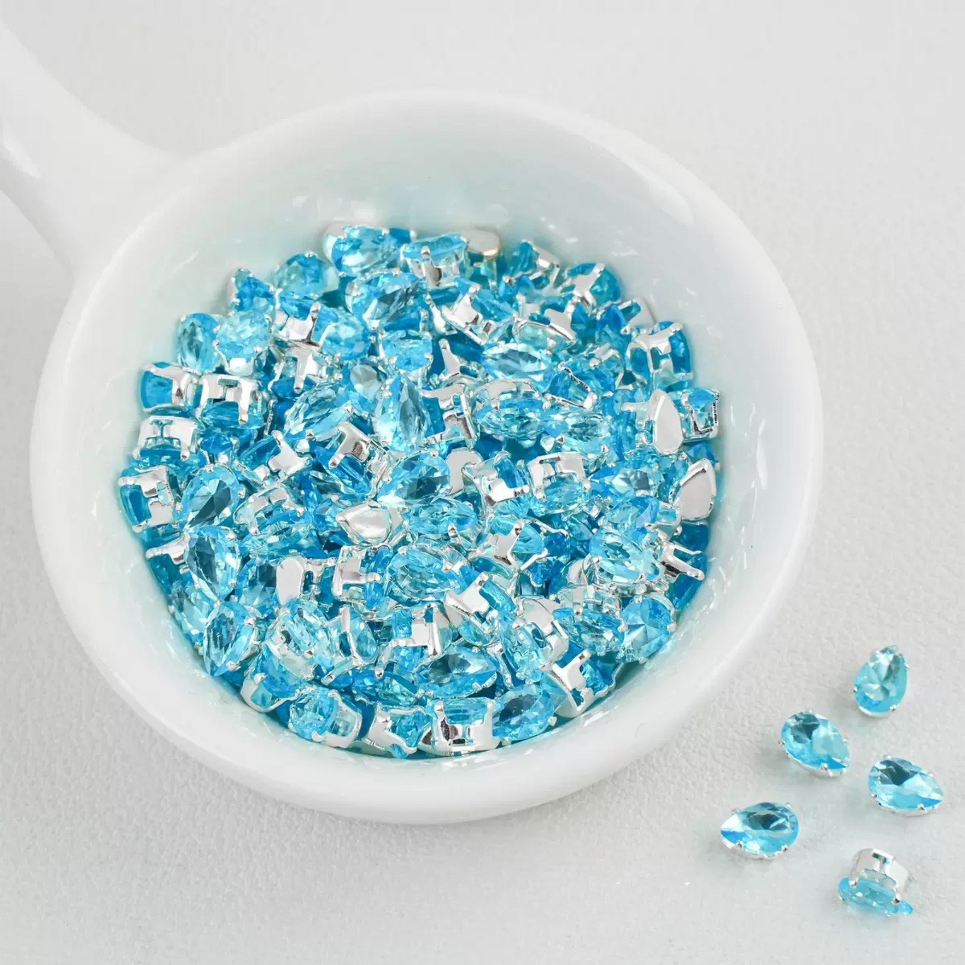 Lake blue teardrop-shaped zircon spacer bead in silver finish