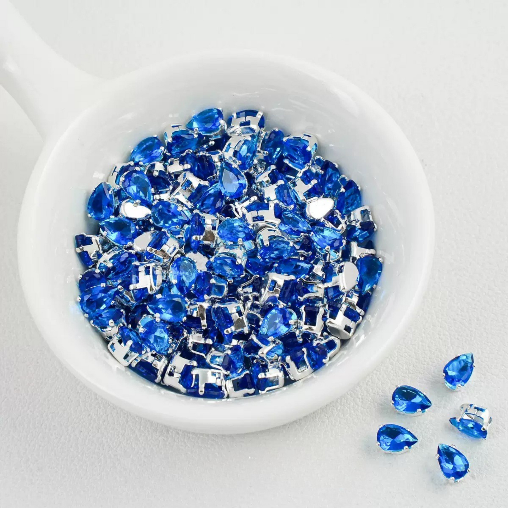 Ocean blue teardrop-shaped zircon spacer bead in silver finish