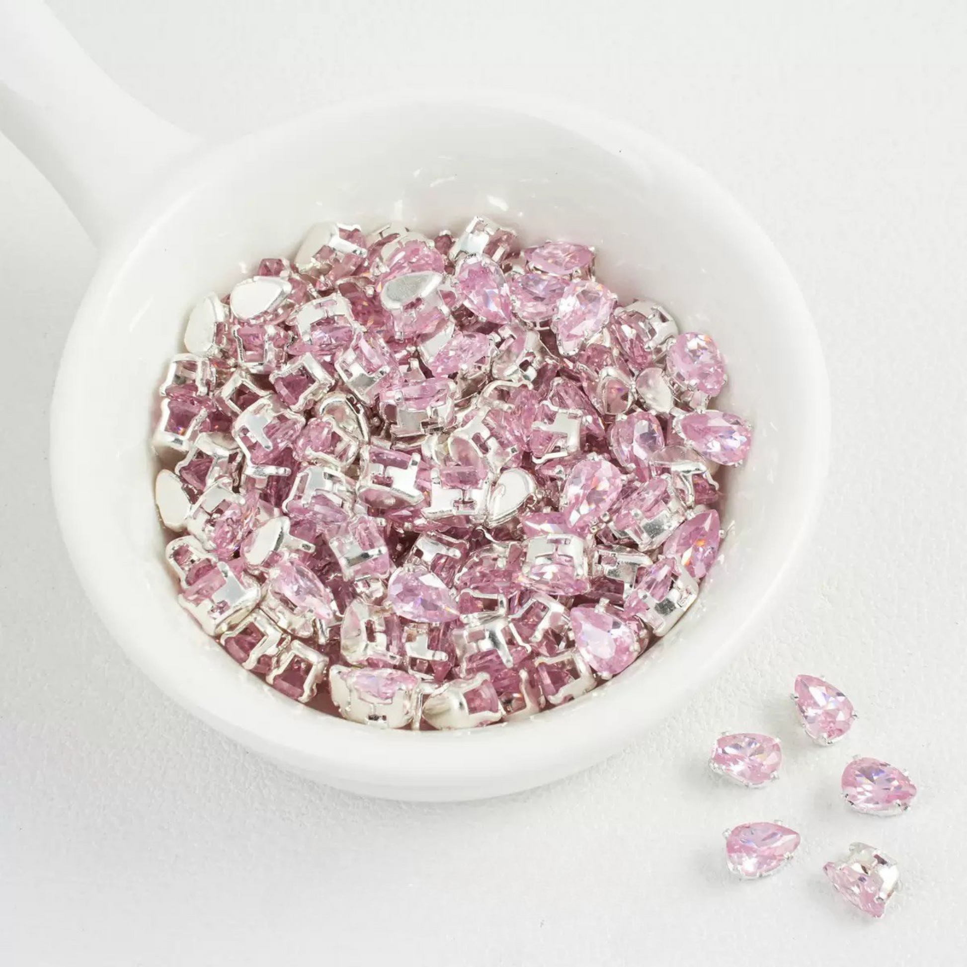 Pink teardrop-shaped zircon spacer bead in silver finish