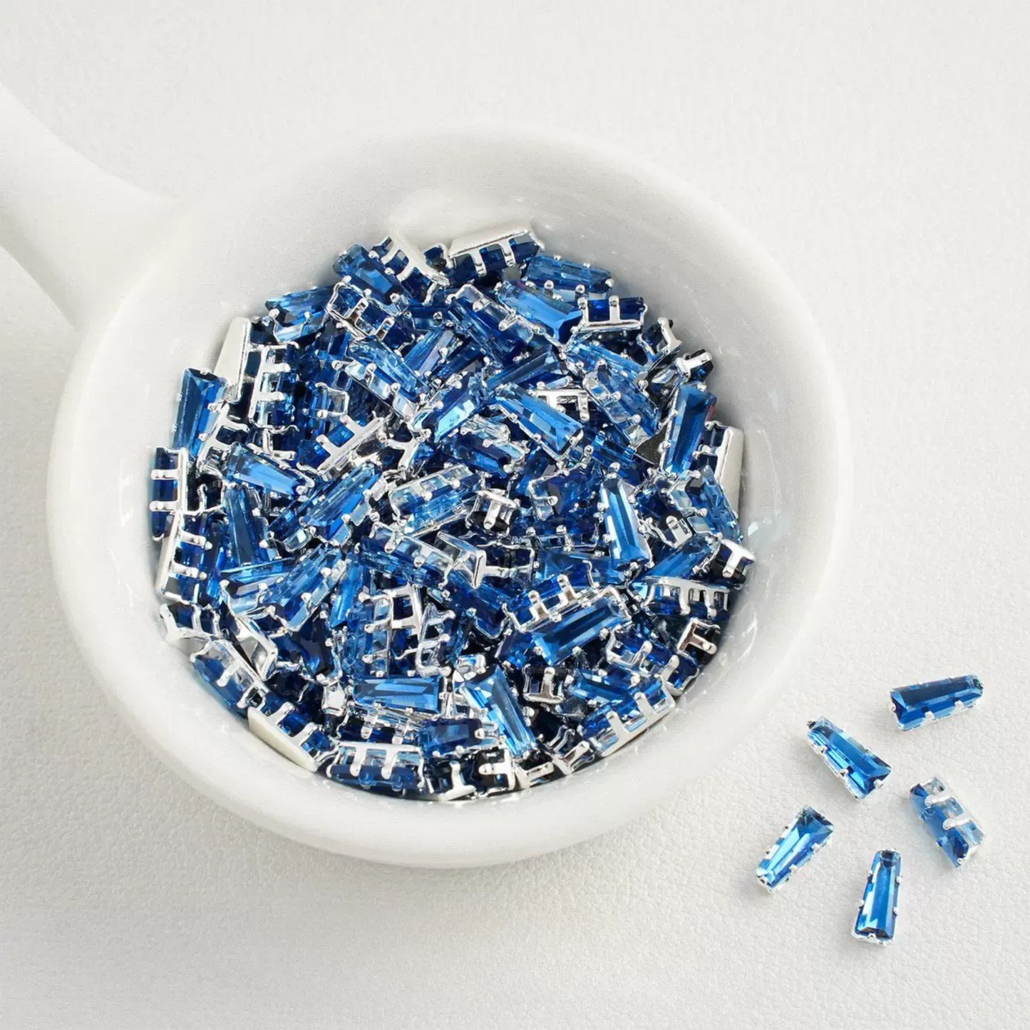 Dark blue trapezoid-shaped zircon spacer with silver backing
