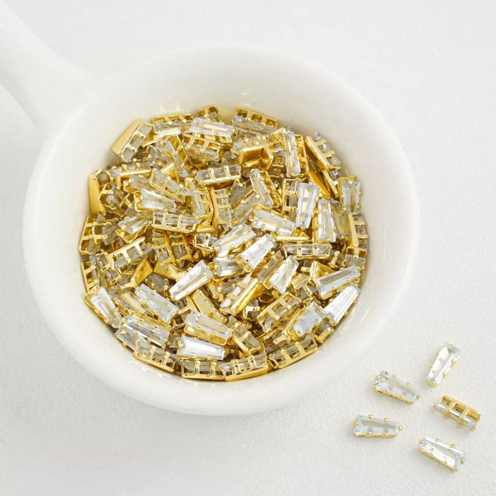 White trapezoid-shaped zircon spacer with gold backing