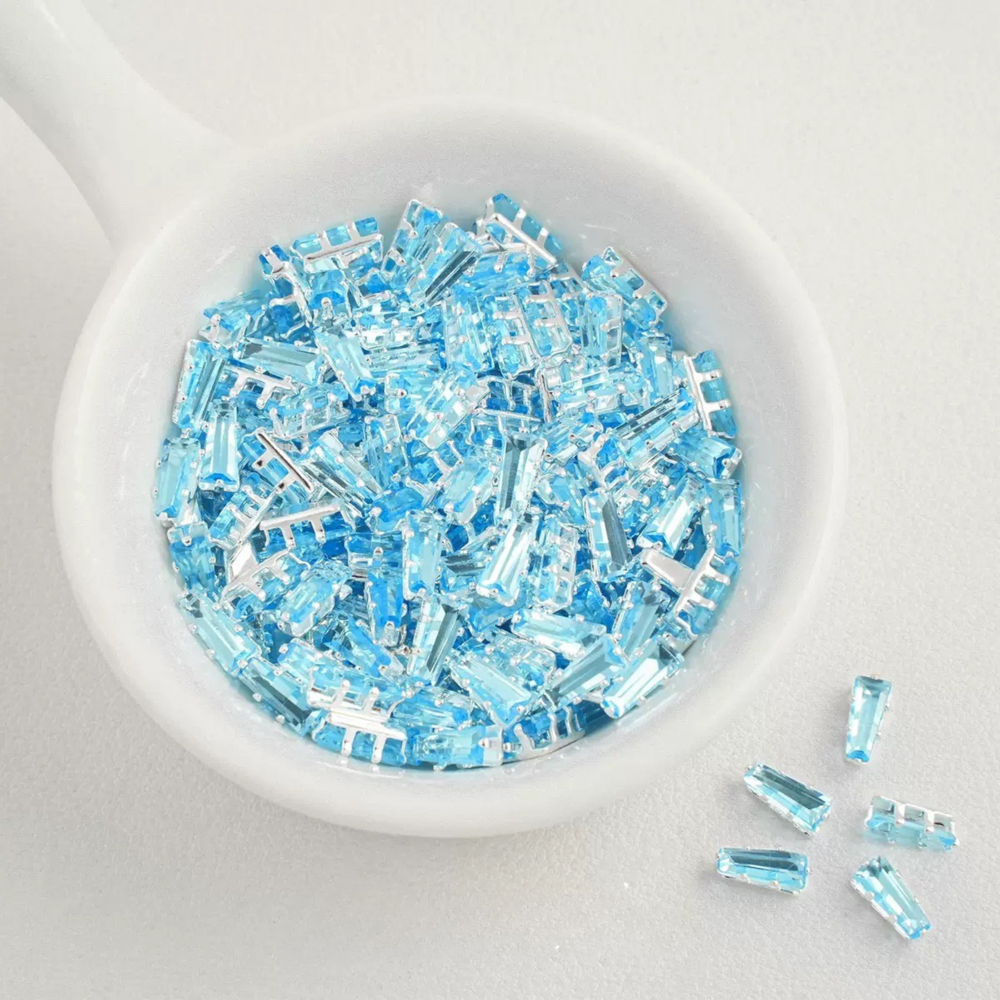 Lake blue trapezoid-shaped zircon spacer with silver backing