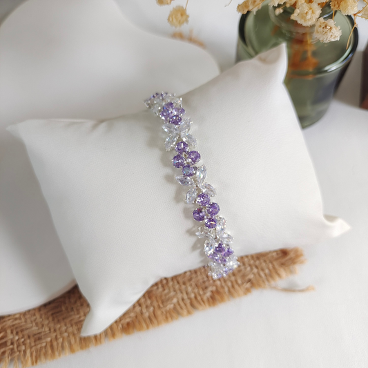 Elegant bracelet with clear marquise and purple round zircon stones on a white cushion