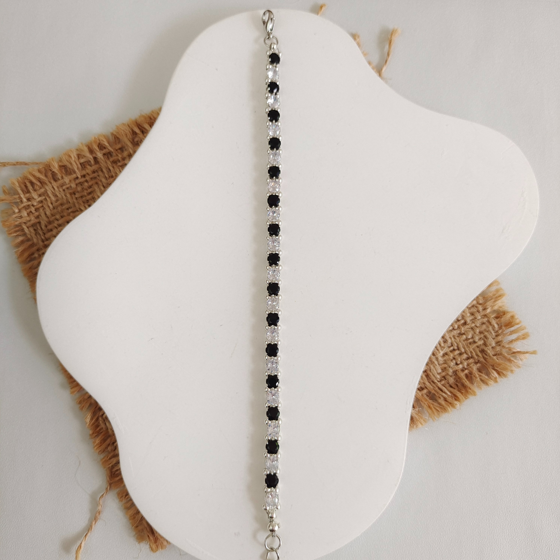 Flat lay of handmade bracelet with black and white round zircon stones