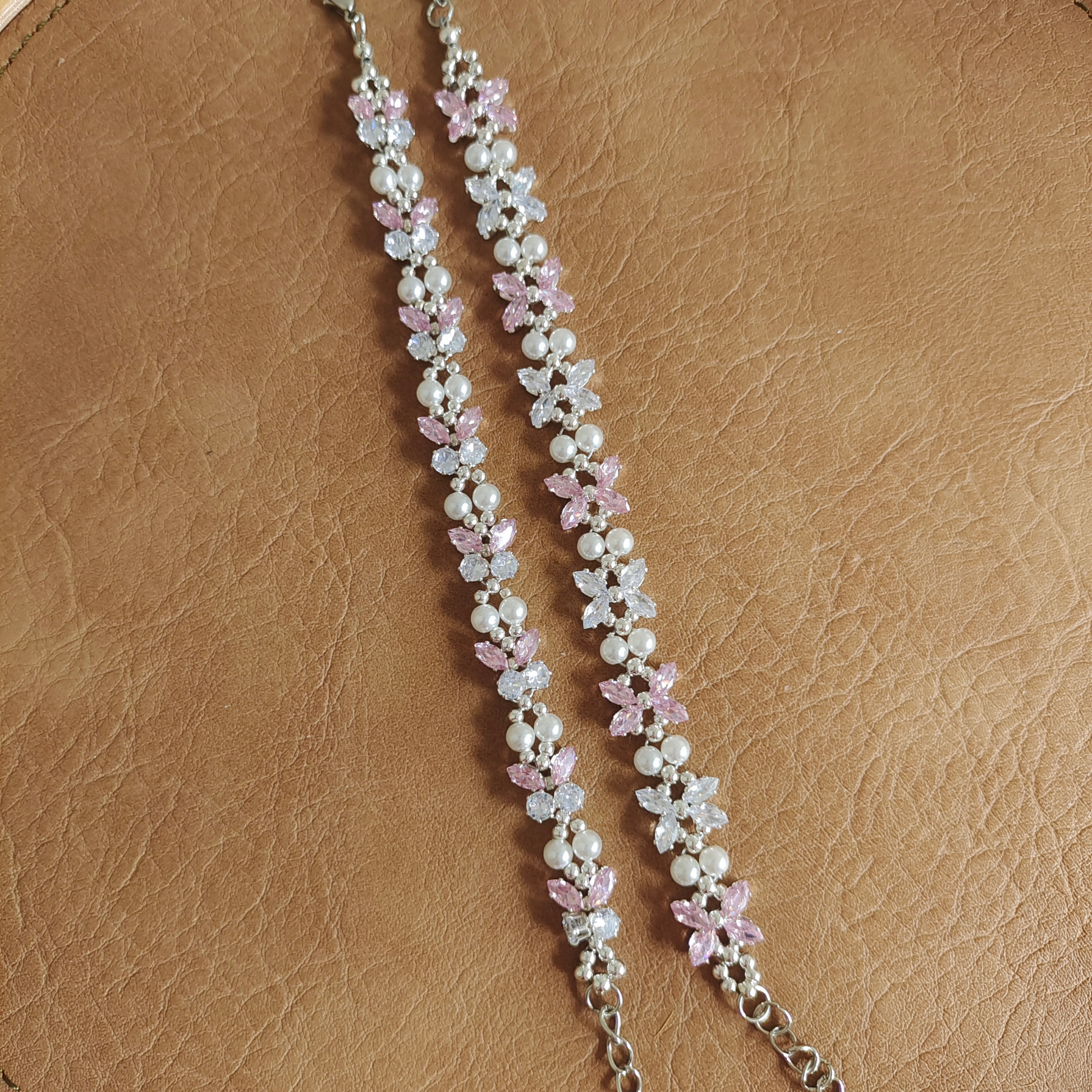 DIY bracelet with silver claw-set zircon gems and classic pearls, flat view