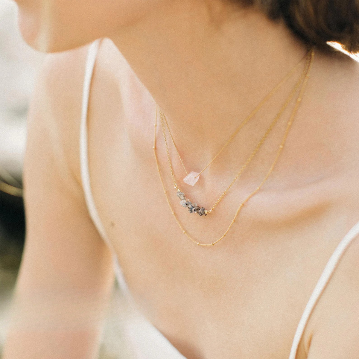 Model wearing handmade clear quartz pendant necklace with raw crystal