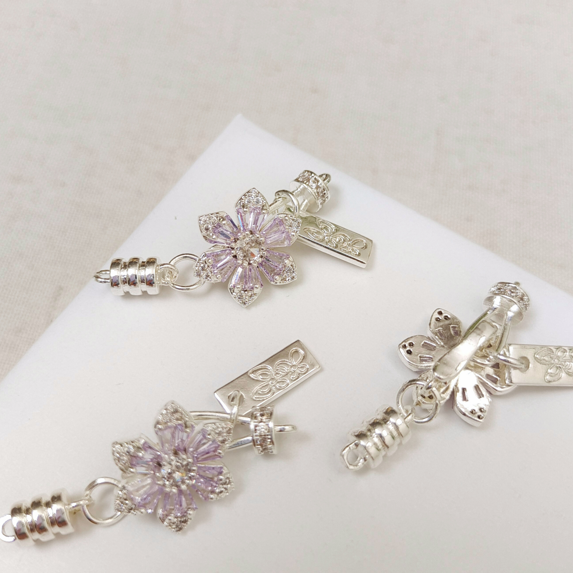 Front and back view of purple zircon cherry blossom clasp