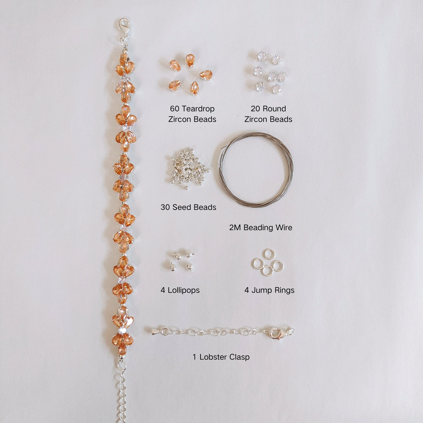 DIY bracelet materials: amber crystal drops, white zircon, and tools