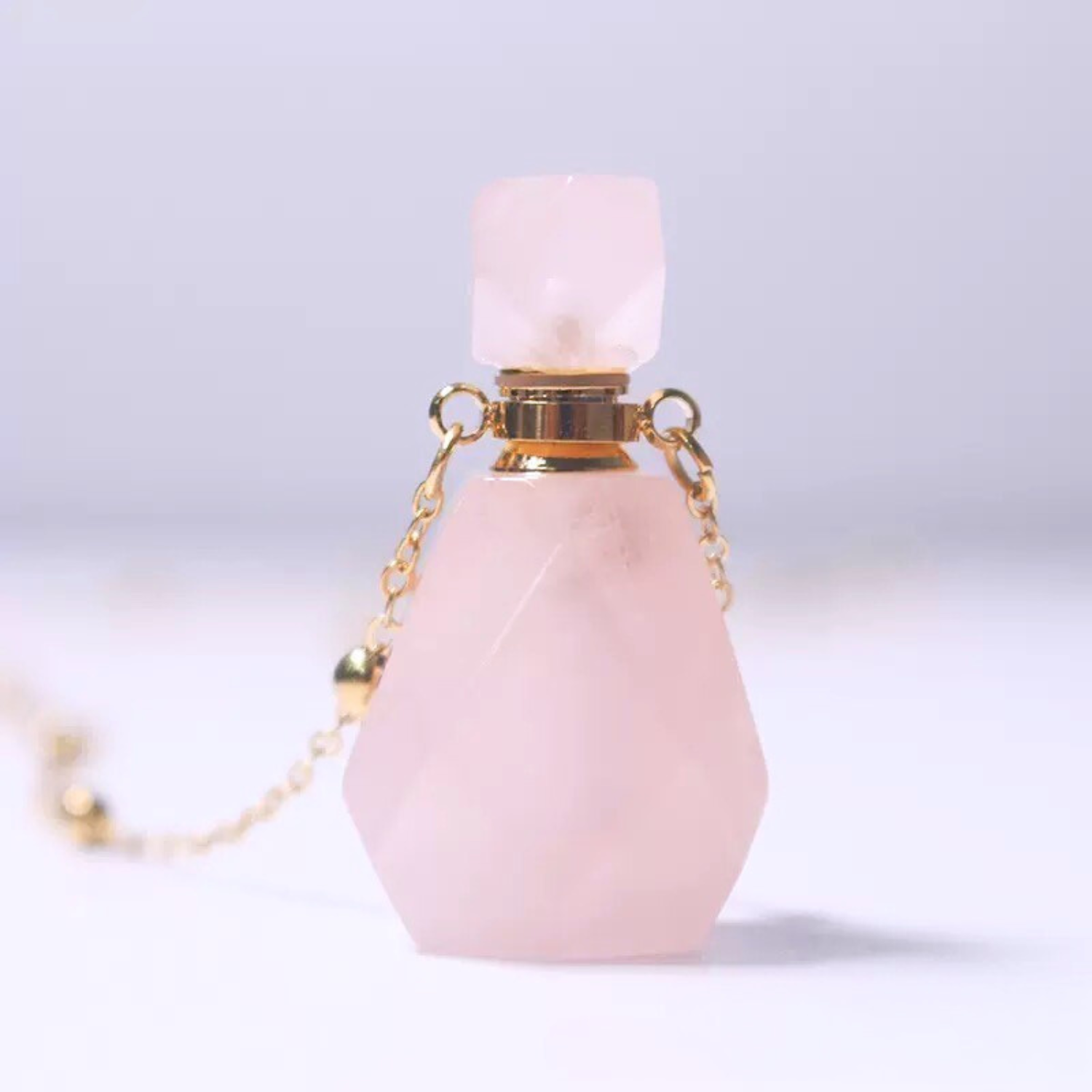 Close-up of rose quartz perfume bottle pendant necklace