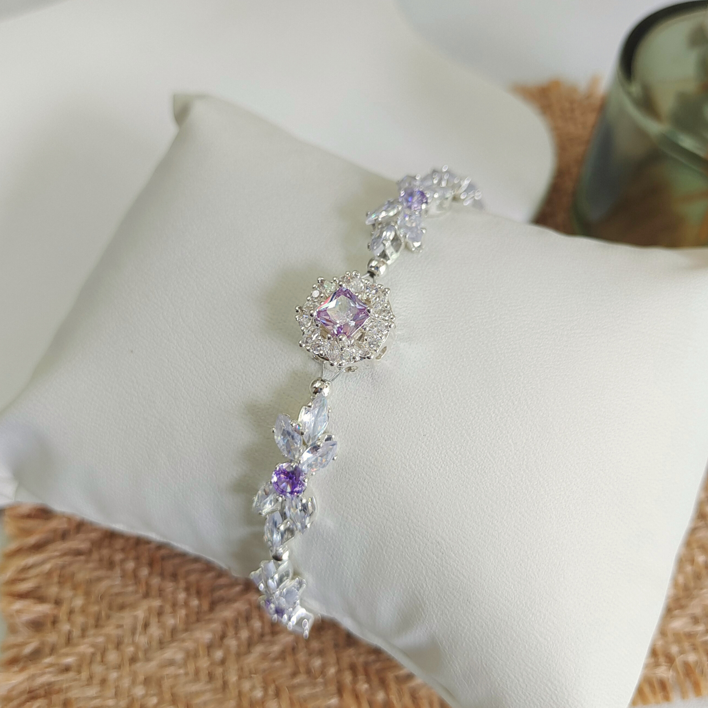 Close-up of bow bracelet with clear marquise CZ and purple round stones with large violet spacer