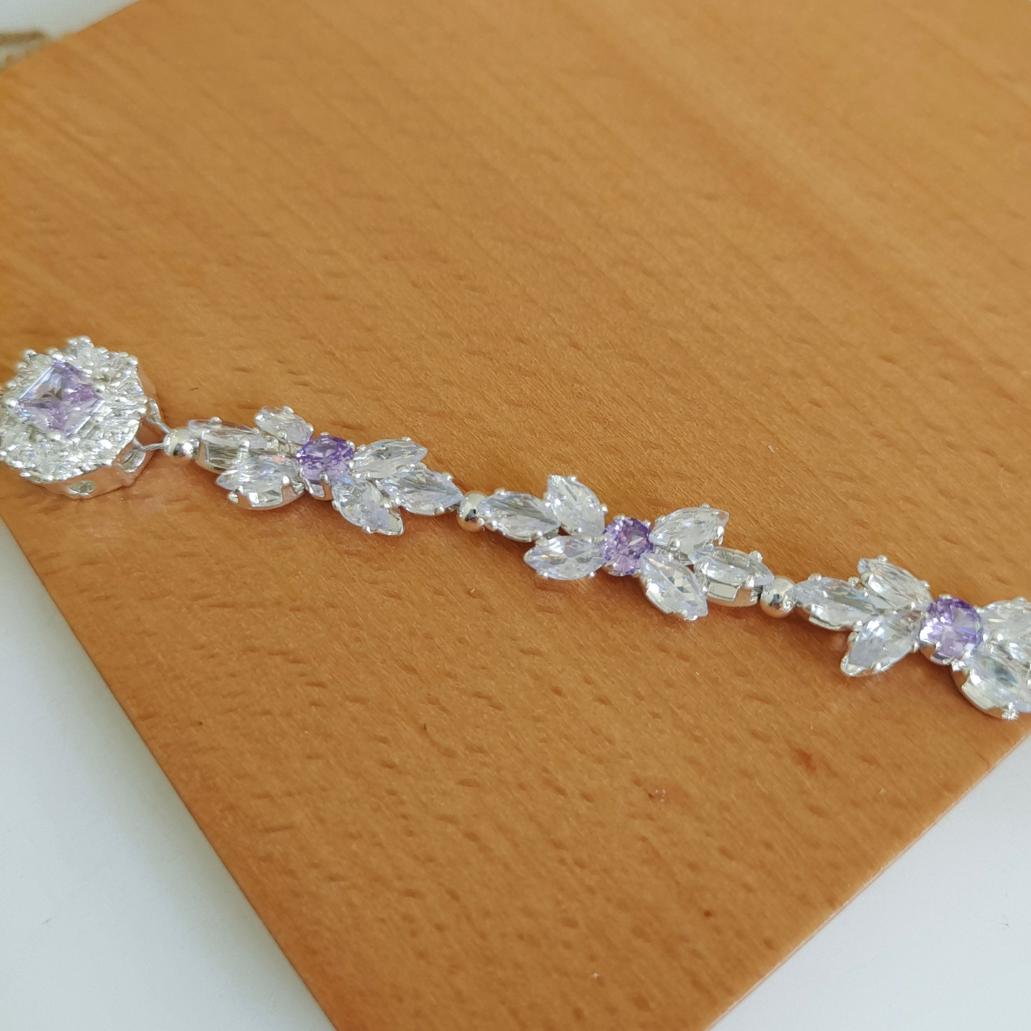Detail view of handmade bracelet featuring clear marquise and purple CZ with focal spacer bead