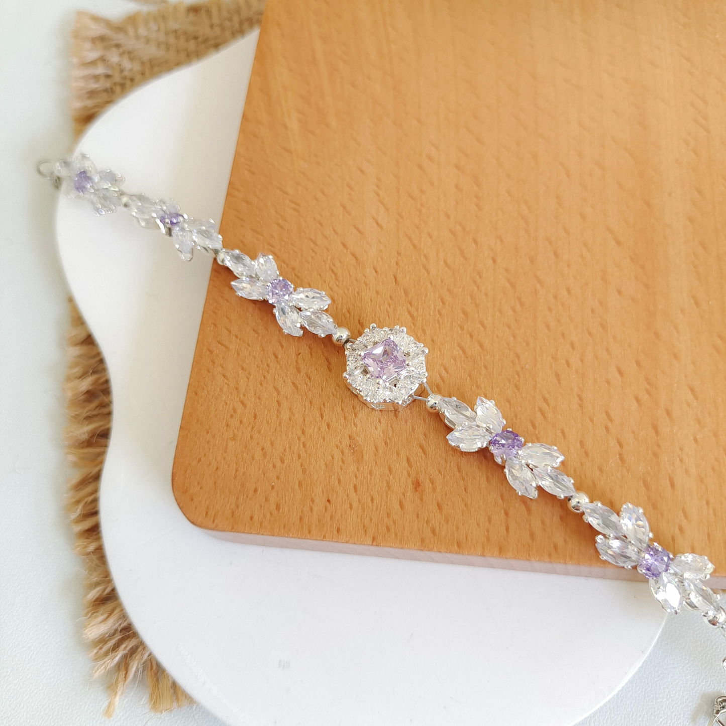 Zoomed-in shot of zircon bow bracelet with crystal marquise and large purple bead detail