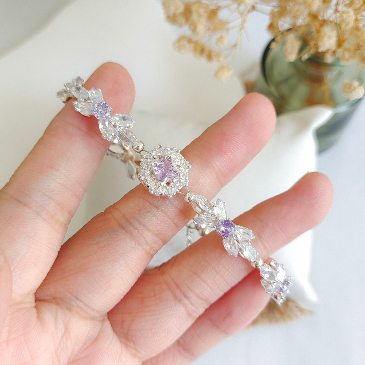 Purple and clear CZ bracelet detail with bow design and bold violet spacer charm