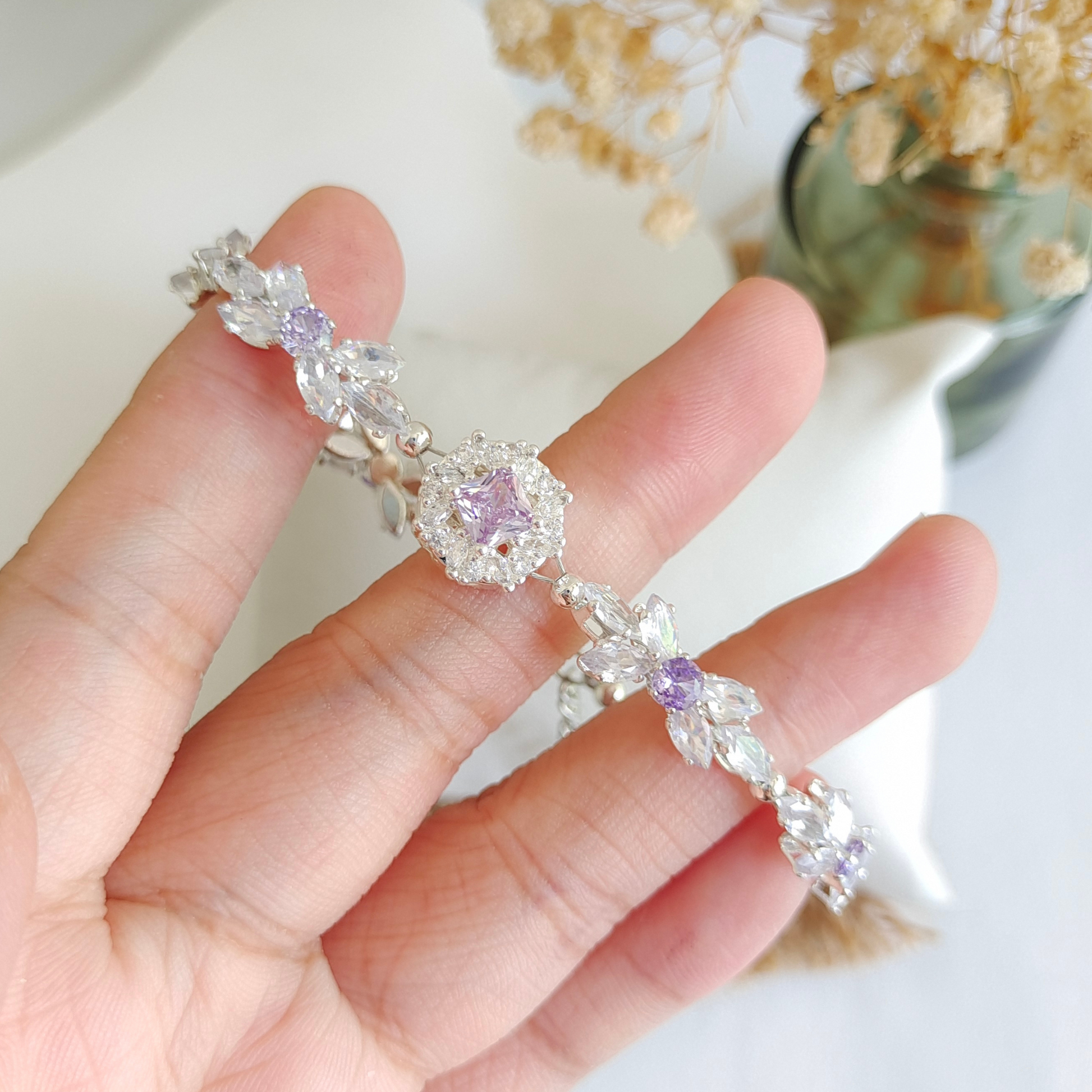 Purple and clear CZ bracelet detail with bow design and bold violet spacer charm