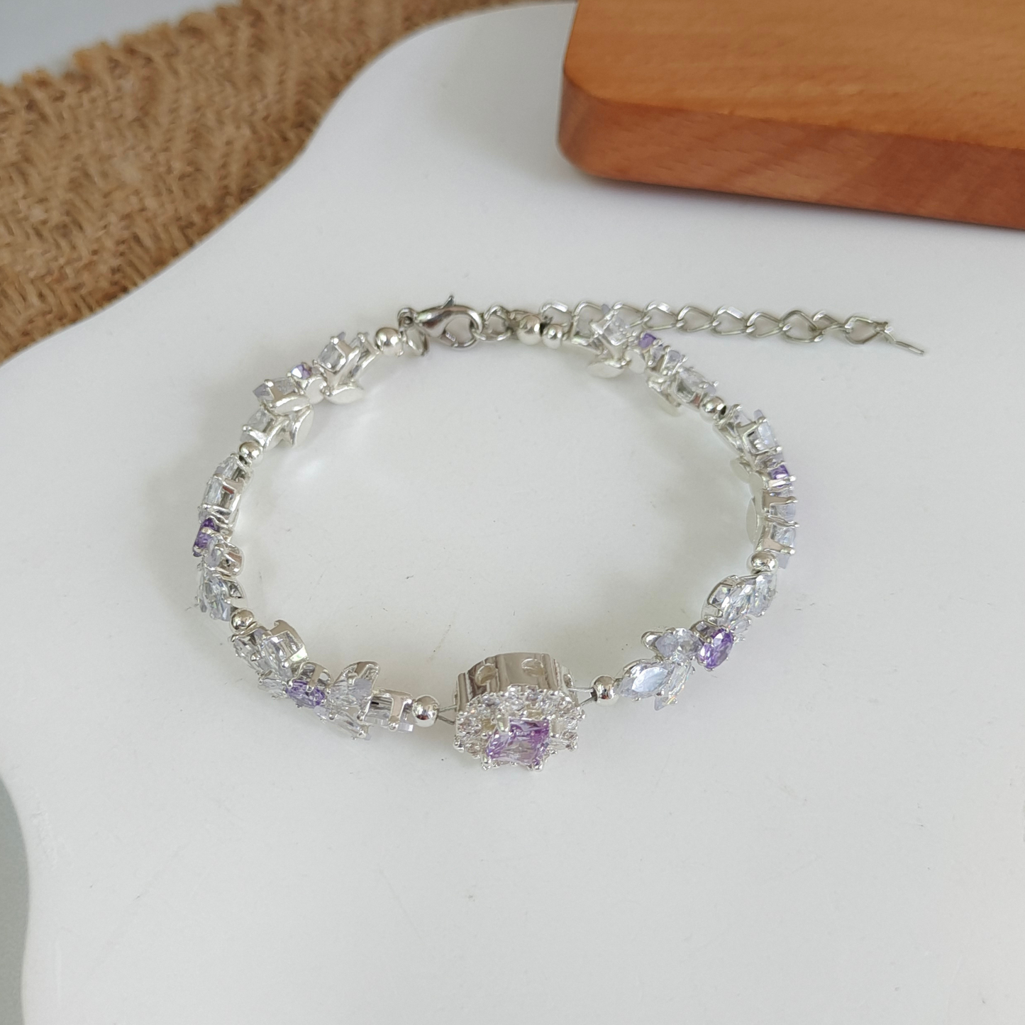 Purple and clear cubic zirconia bracelet with bow design and violet center bead