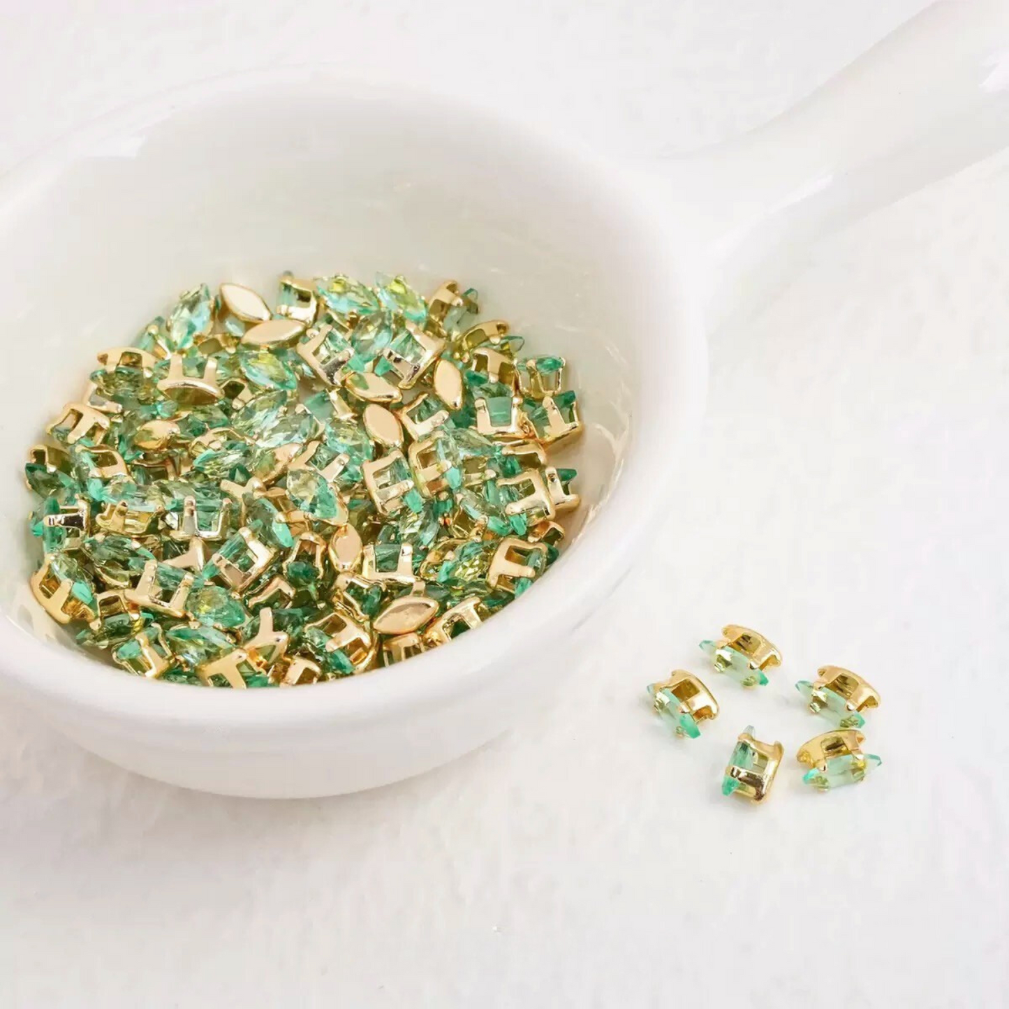 Lake green marquise-shaped zirconia gems with gold-tone claw