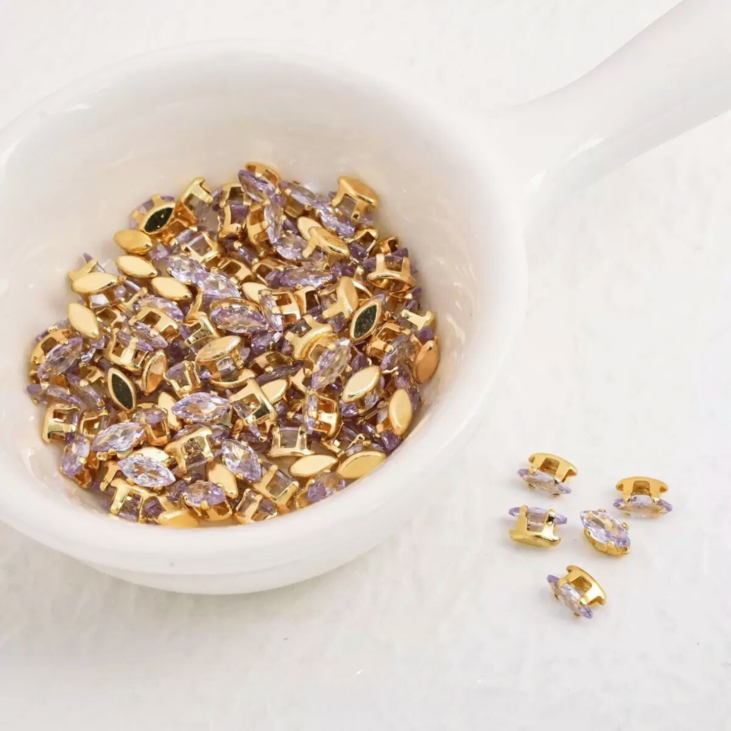 Light purple marquise-shaped zirconia gems with gold-tone claw