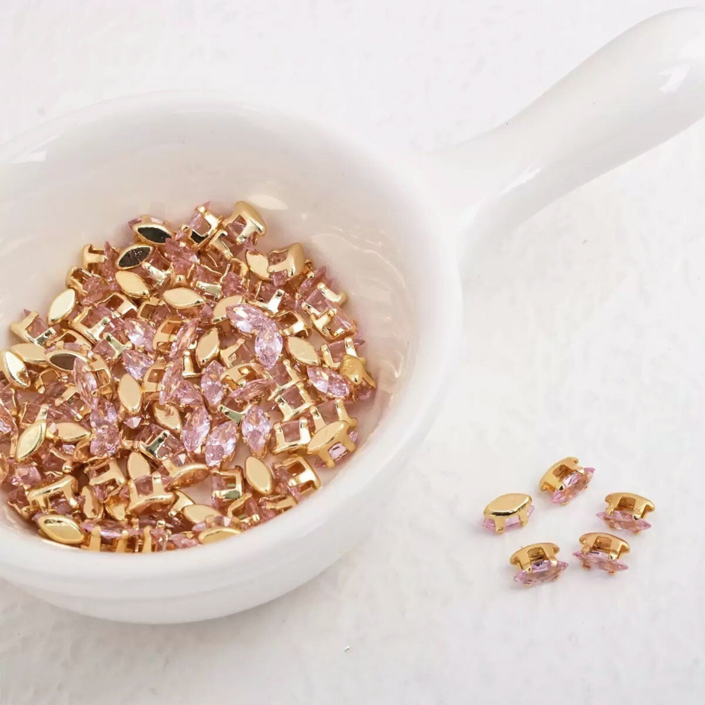 Pink marquise-shaped zirconia gems with gold-tone claw