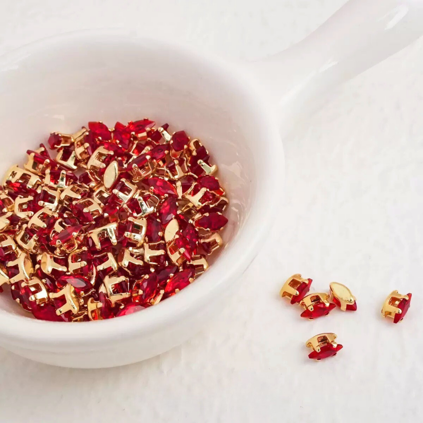 Red marquise-shaped zirconia gems with gold-tone claw
