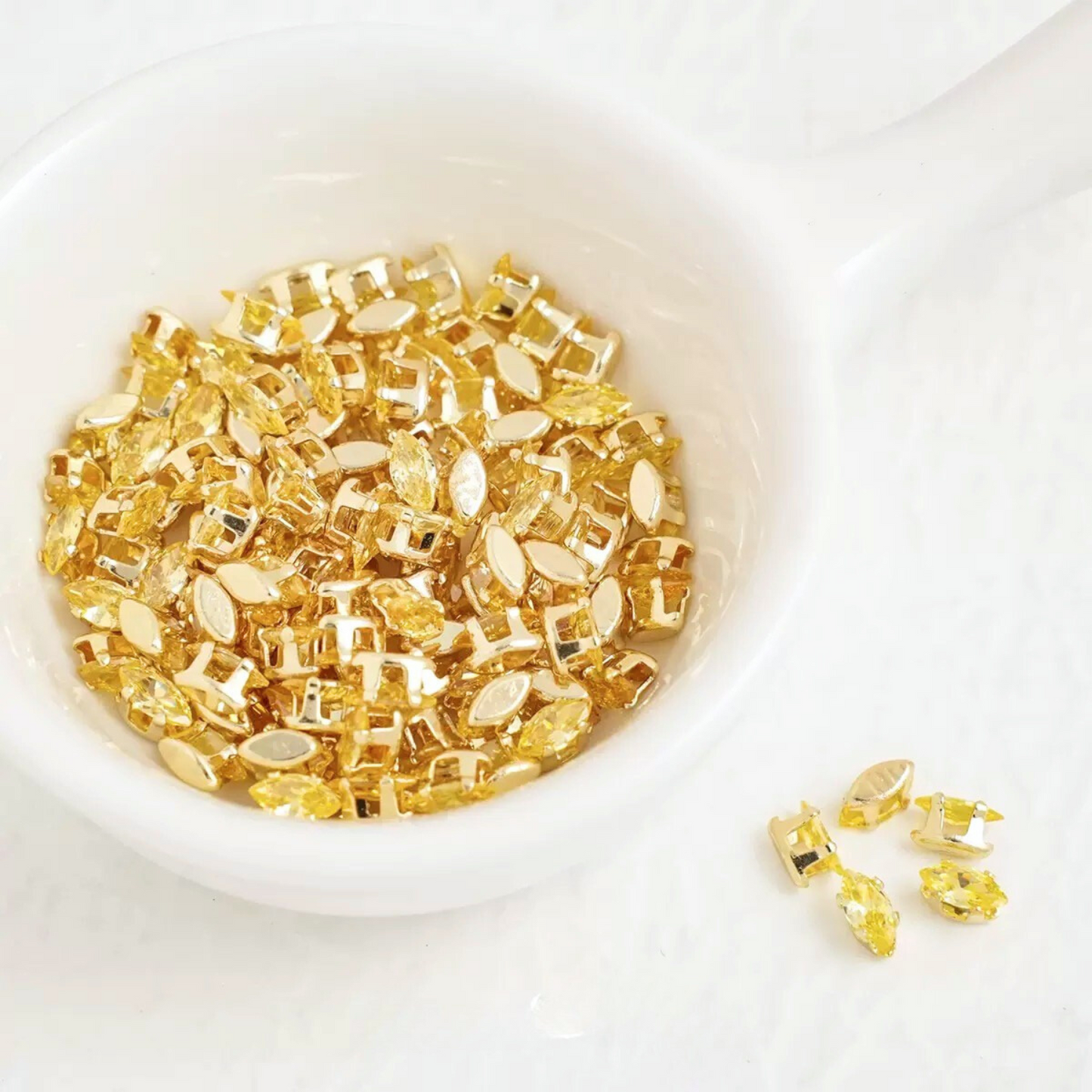 Yellow marquise-shaped zirconia gems with gold-tone claw